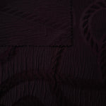 Pattern detail of burgundy wheat leaf polyester crepe jacquard fabric with raised texture.