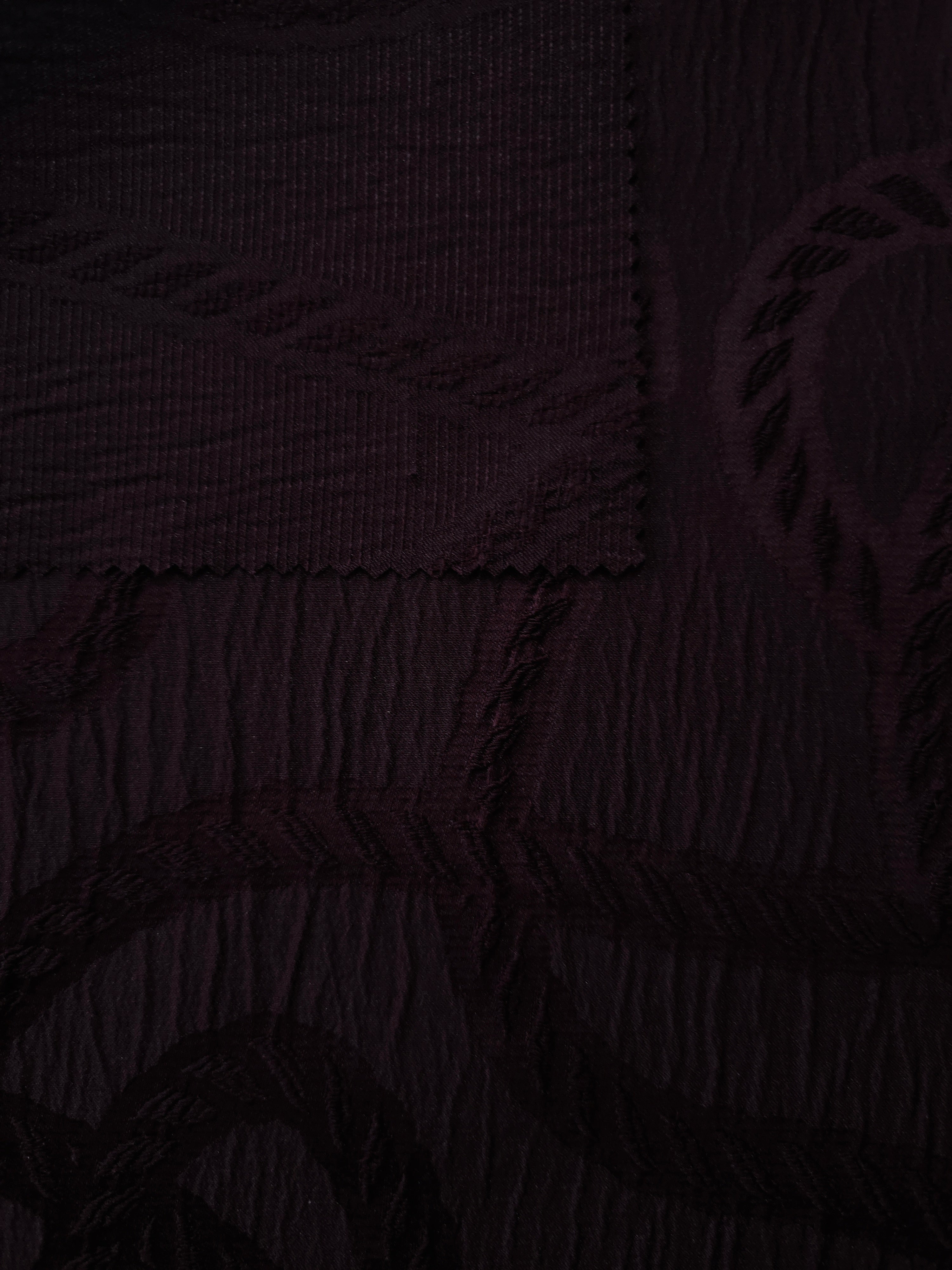 Pattern detail of burgundy wheat leaf polyester crepe jacquard fabric with raised texture.