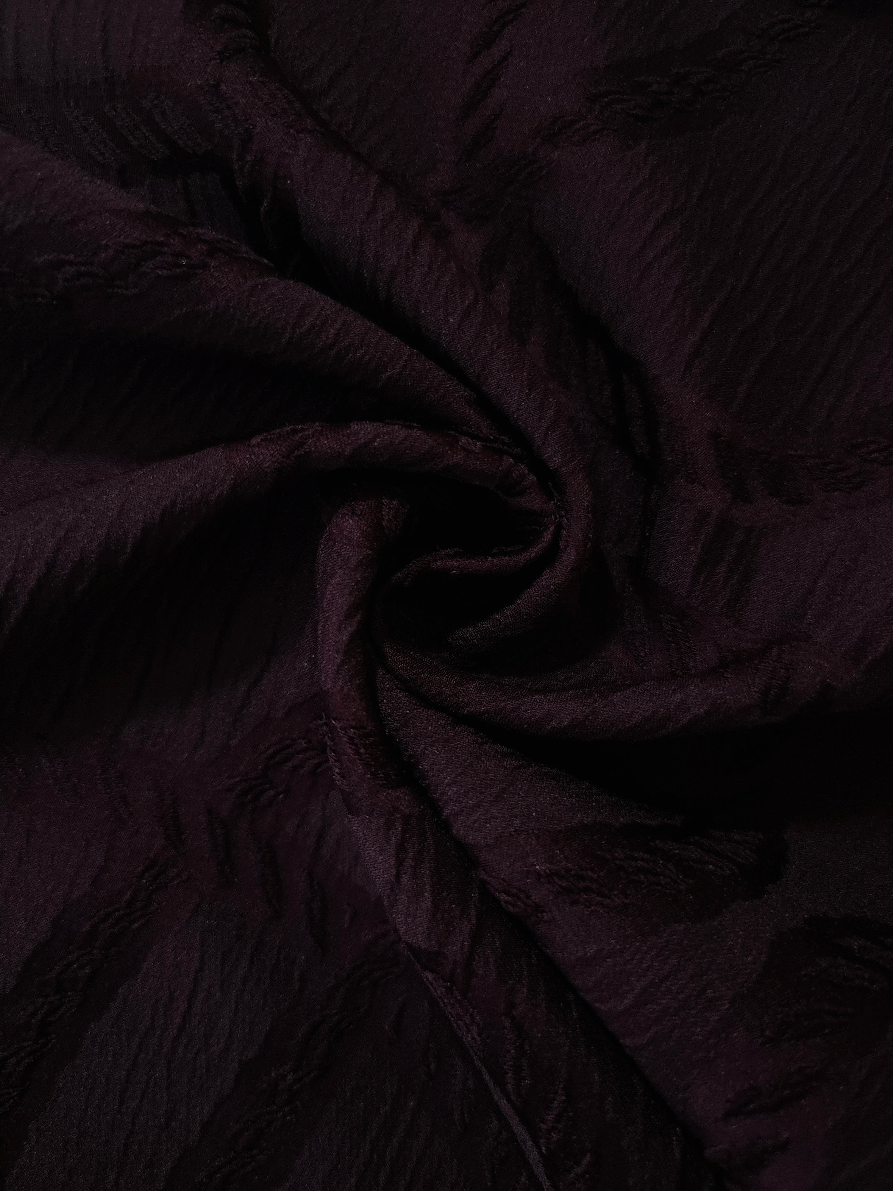 Wide view of burgundy wheat leaf polyester crepe jacquard fabric for occasionwear layers.