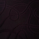 Drape view of burgundy wheat leaf polyester crepe jacquard fabric for dresses and skirts.