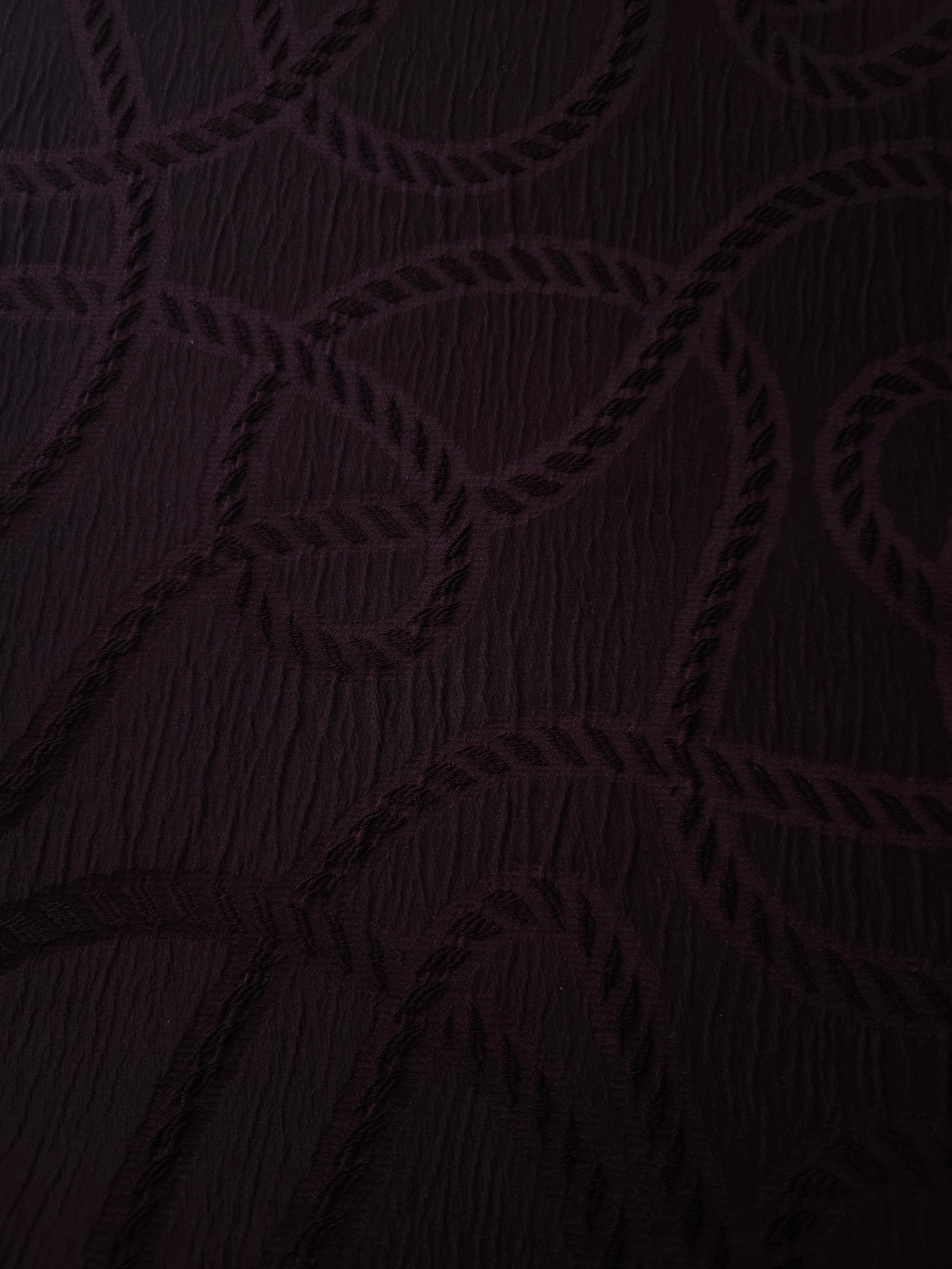 Drape view of burgundy wheat leaf polyester crepe jacquard fabric for dresses and skirts.