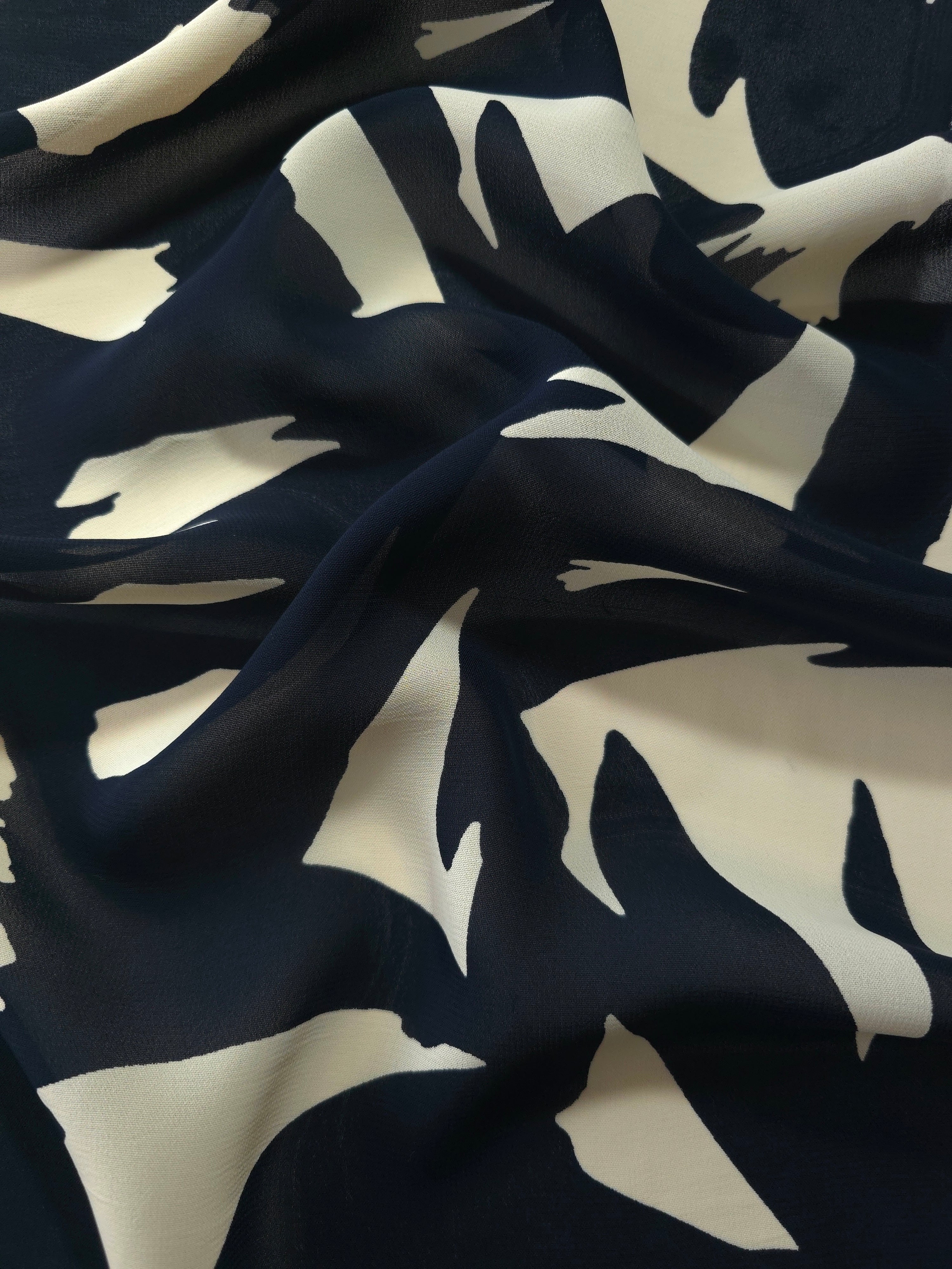 Wave fold of black rayon Empirme fabric with big flower print for occasion layers.