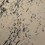 Close-up of black printed rayon chiffon showing graphic Empirme pattern and light weave.
