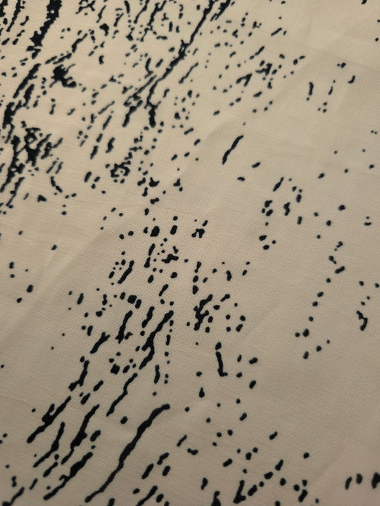 Close-up of black printed rayon chiffon showing graphic Empirme pattern and light weave.