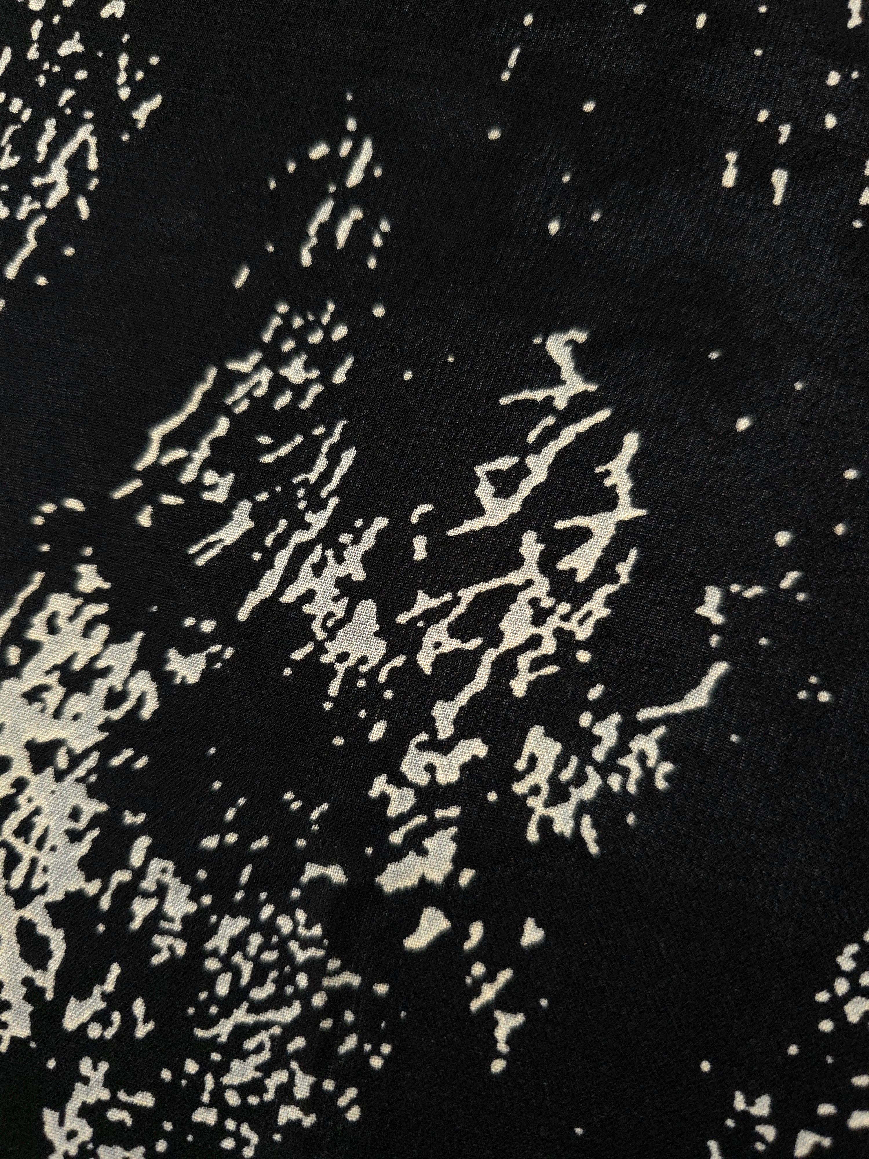 Close-up of white printed rayon chiffon showing graphic Empirme pattern and soft hand.