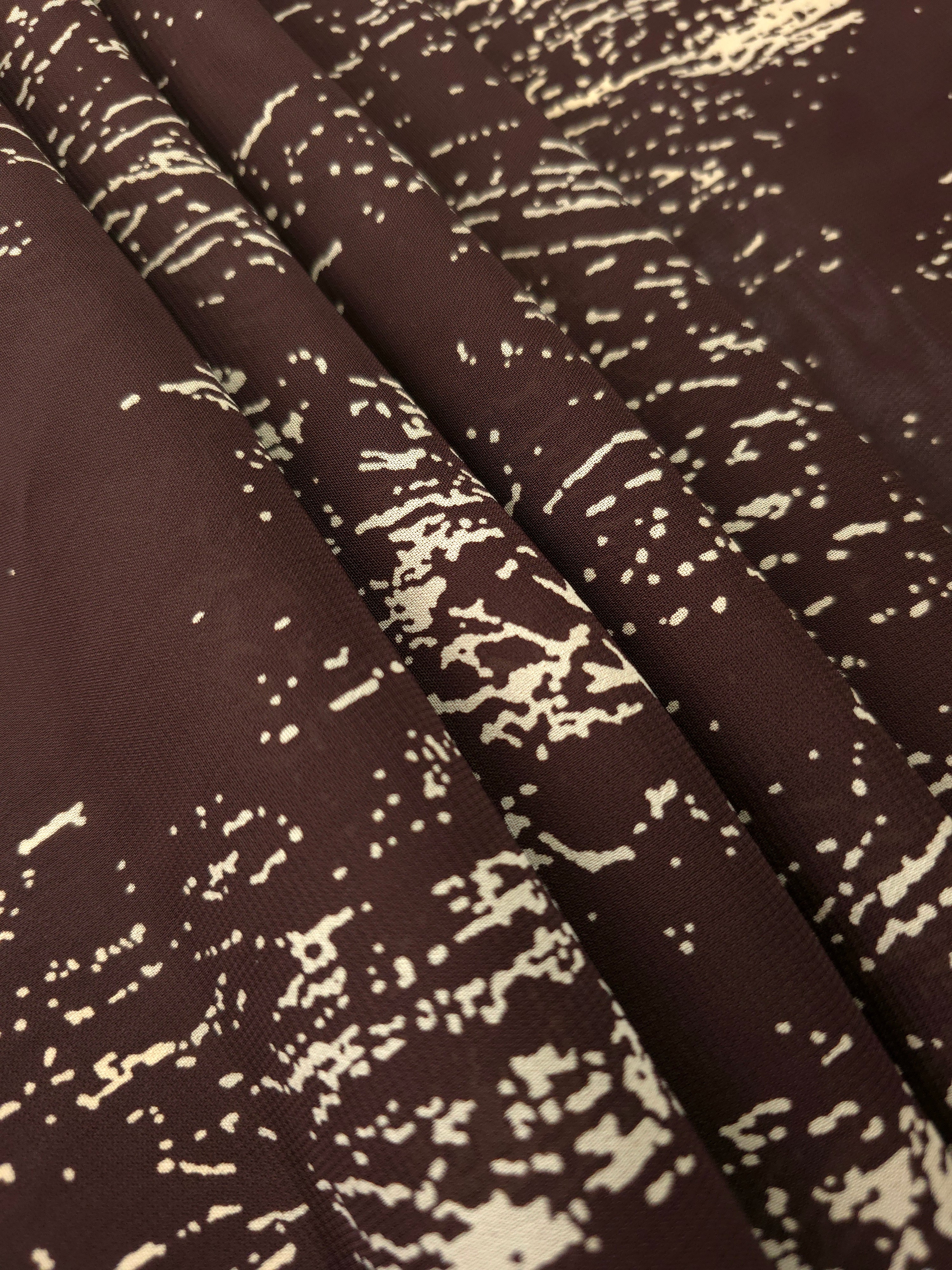 Folded brown rayon chiffon Empirme with graphic print for soft dresses and layers.