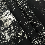 Folded white rayon chiffon Empirme with graphic print for lined dress layers.
