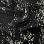 Wave fold of white rayon Empirme fabric with graphic print for summer dresses.