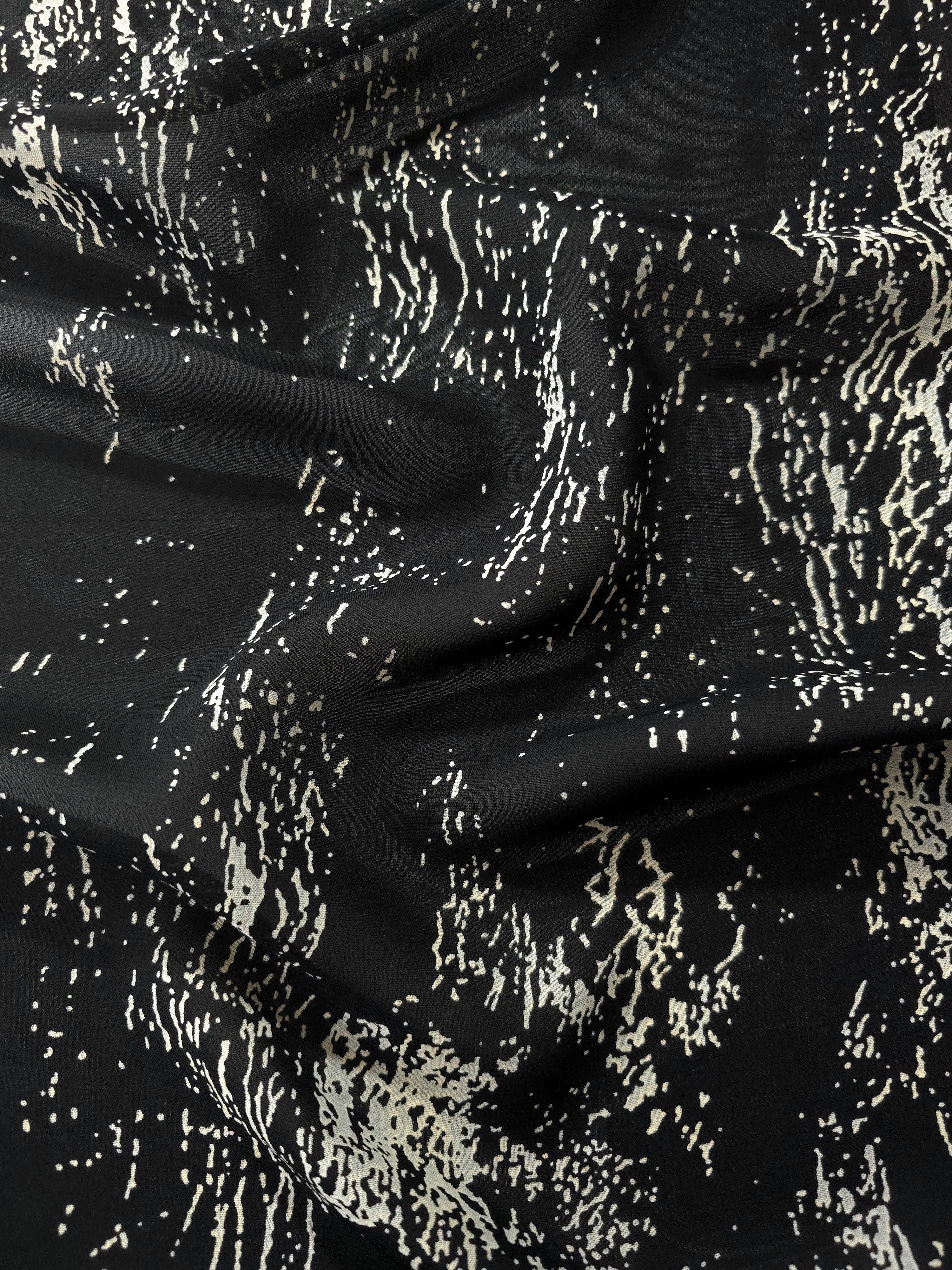 Wave fold of white rayon Empirme fabric with graphic print for summer dresses.