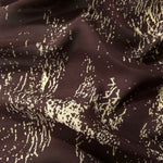 Wave fold of brown rayon Empirme fabric with graphic print for flowing garments.