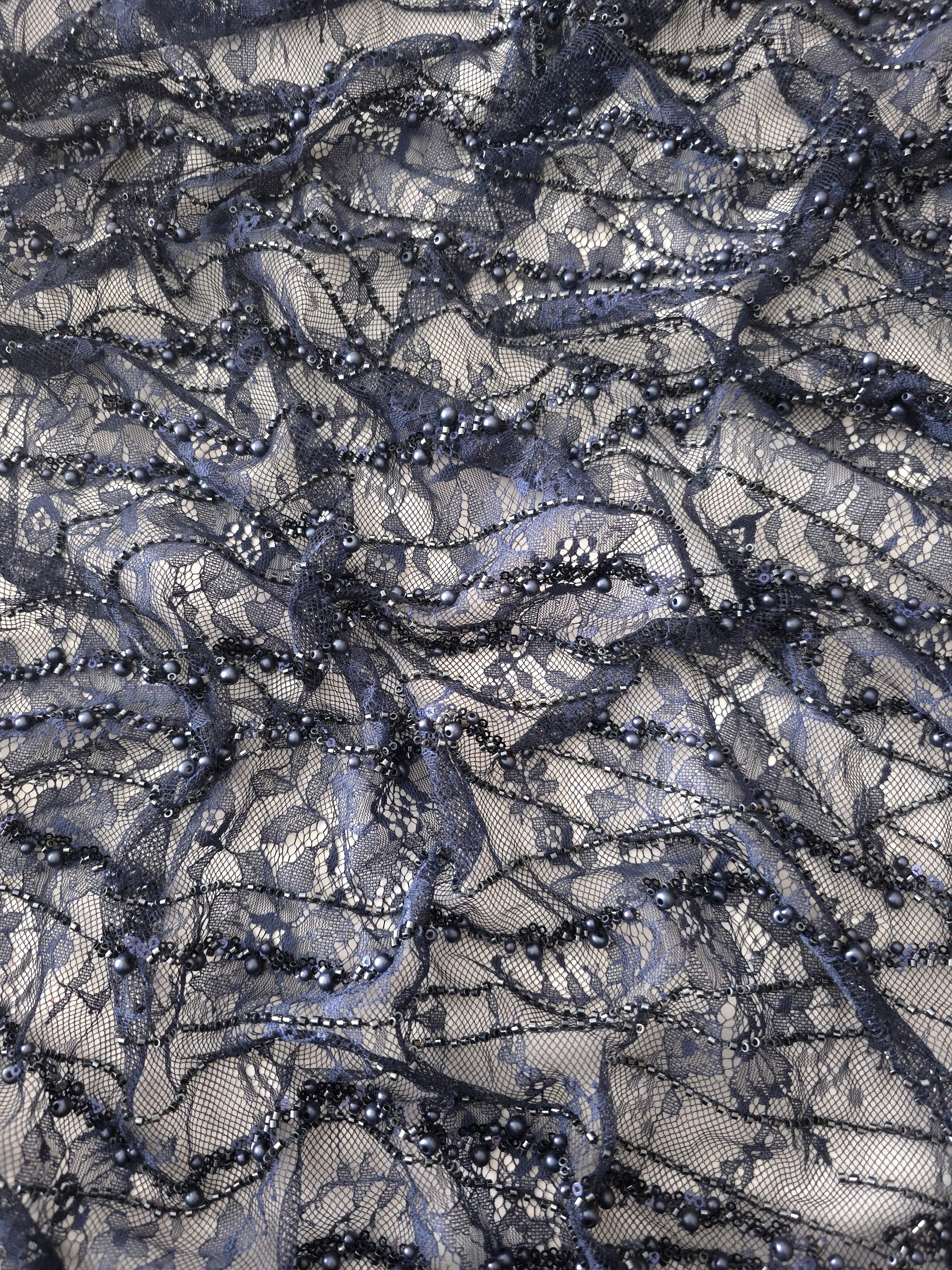 Close-up of Slate Blue Botanical Pearl beaded lace showing curving floral thread detail, with branching botanical vines with pearl-like beading.