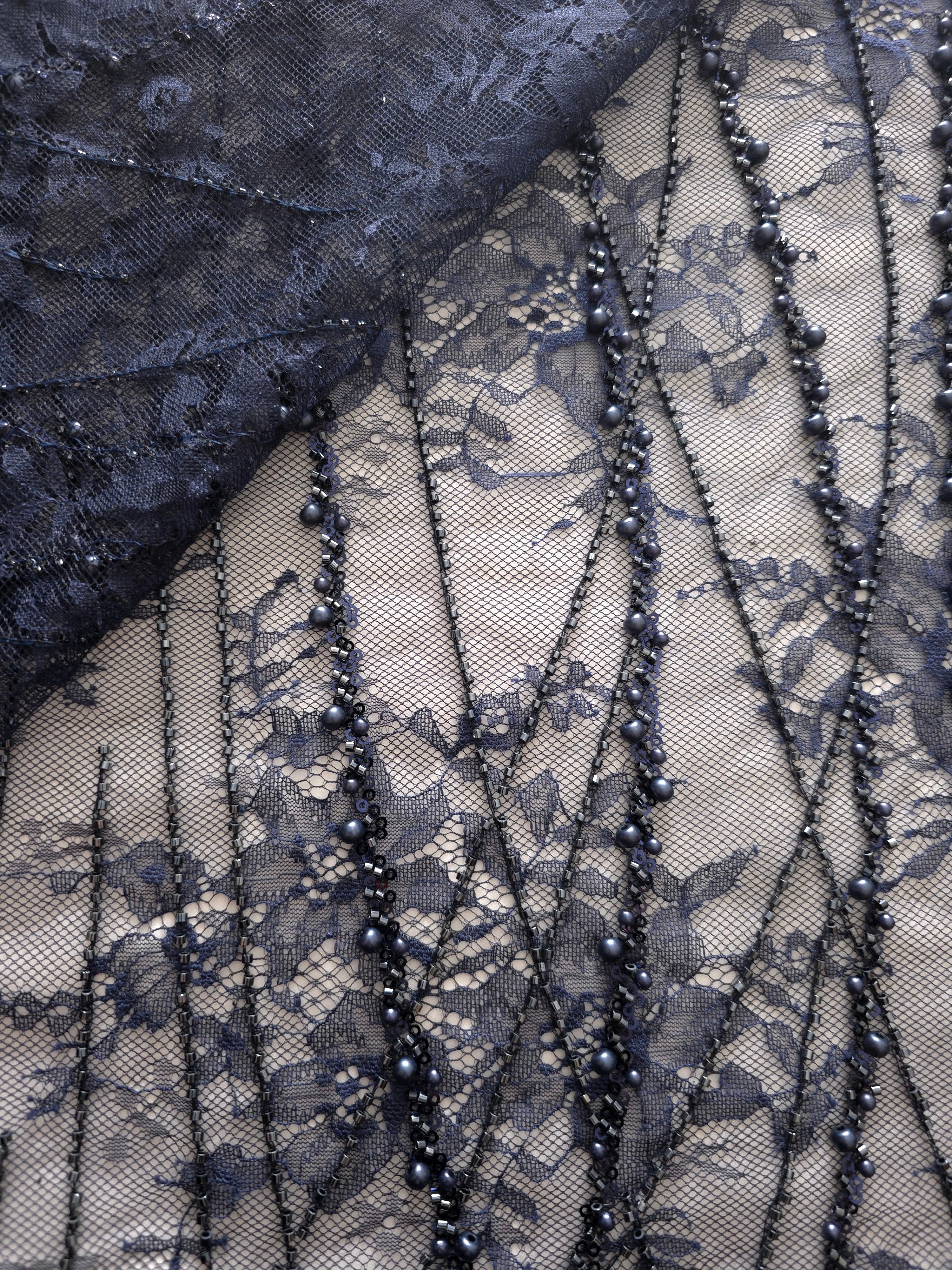 Close-up of Slate Blue Botanical Pearl beaded lace showing pearl beadwork on mesh, with branching botanical vines with pearl-like beading.