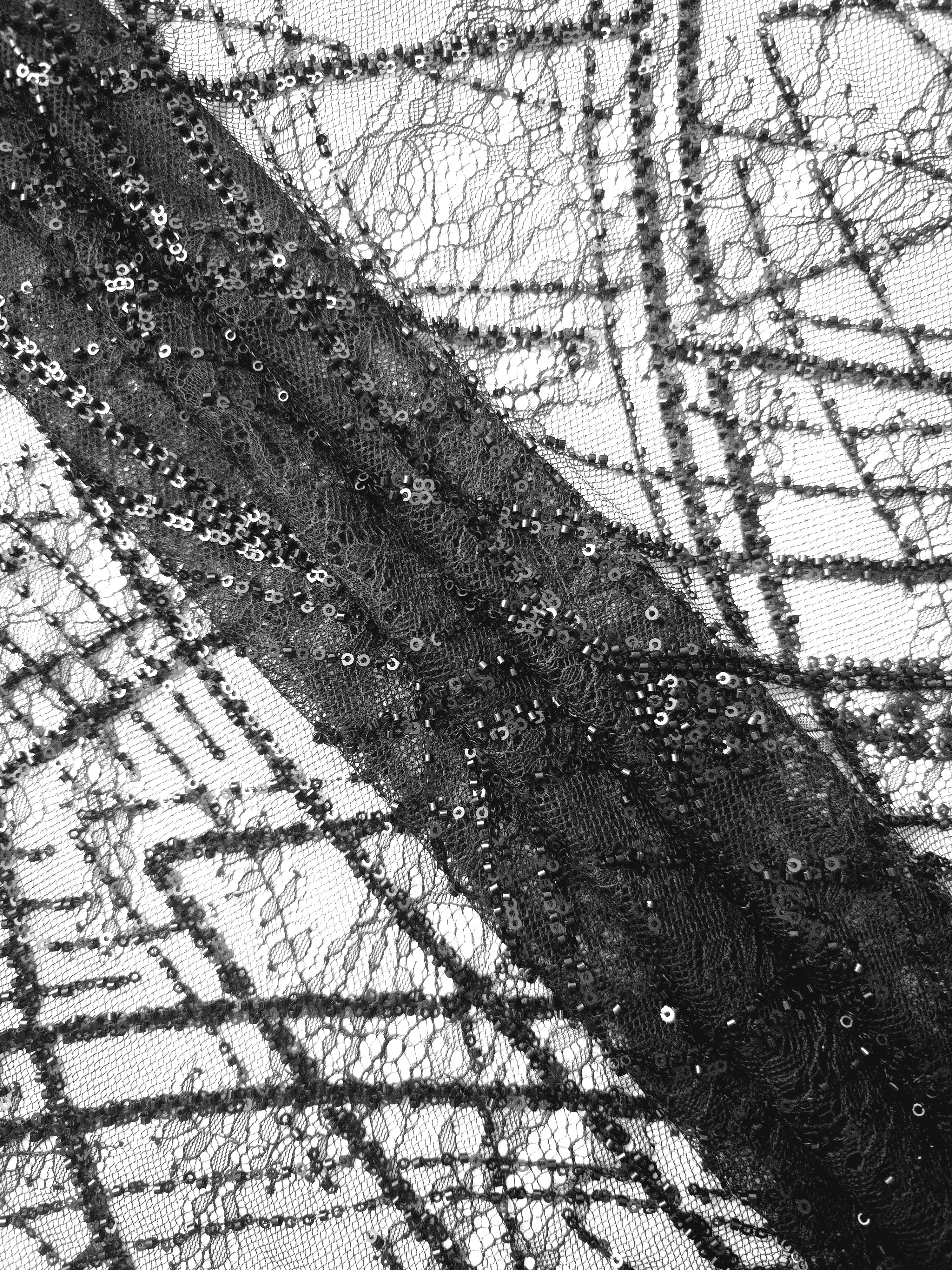 Close-up of Jet Black Ornate Deco Fan beaded lace showing raised black beadwork closeup, with repeating fan arches and geometric embroidery.