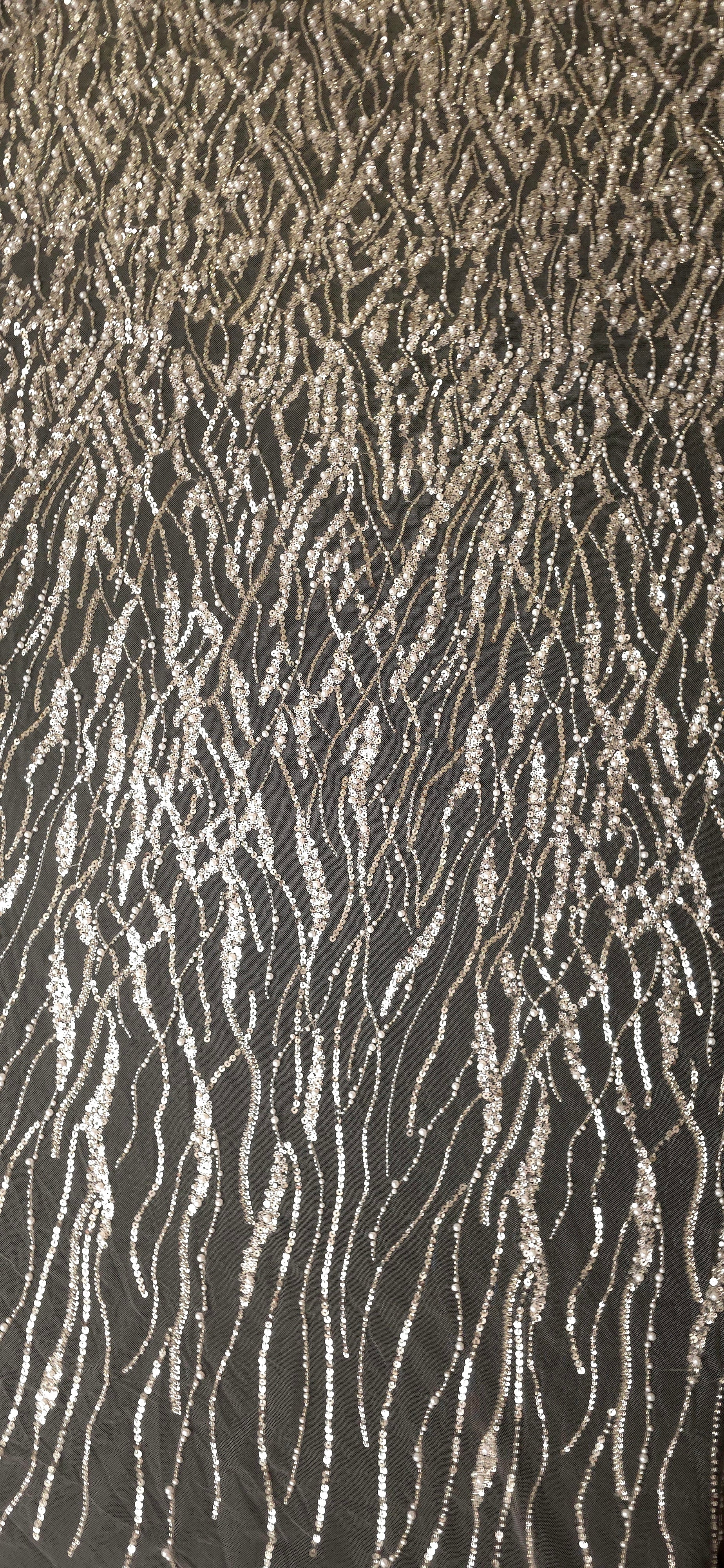 Ivory Silver Liquid Wave embroidered lace showing flowing wave embroidered pattern across a decorative mesh with flowing ripples and curved sequin embellishment.