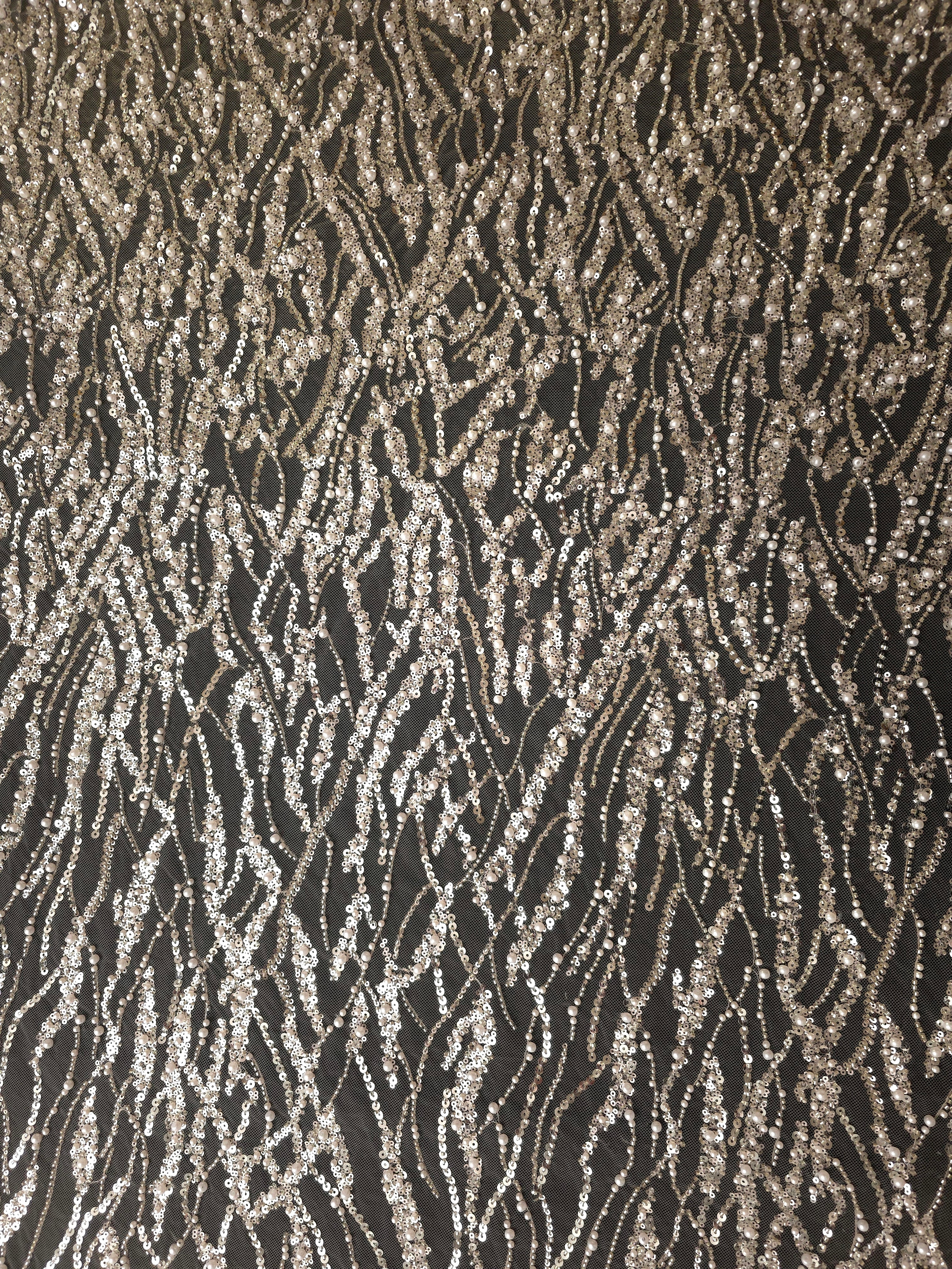 Ivory Silver Liquid Wave embroidered lace showing organic ripple motif repeat across a decorative mesh with flowing ripples and curved sequin embellishment.
