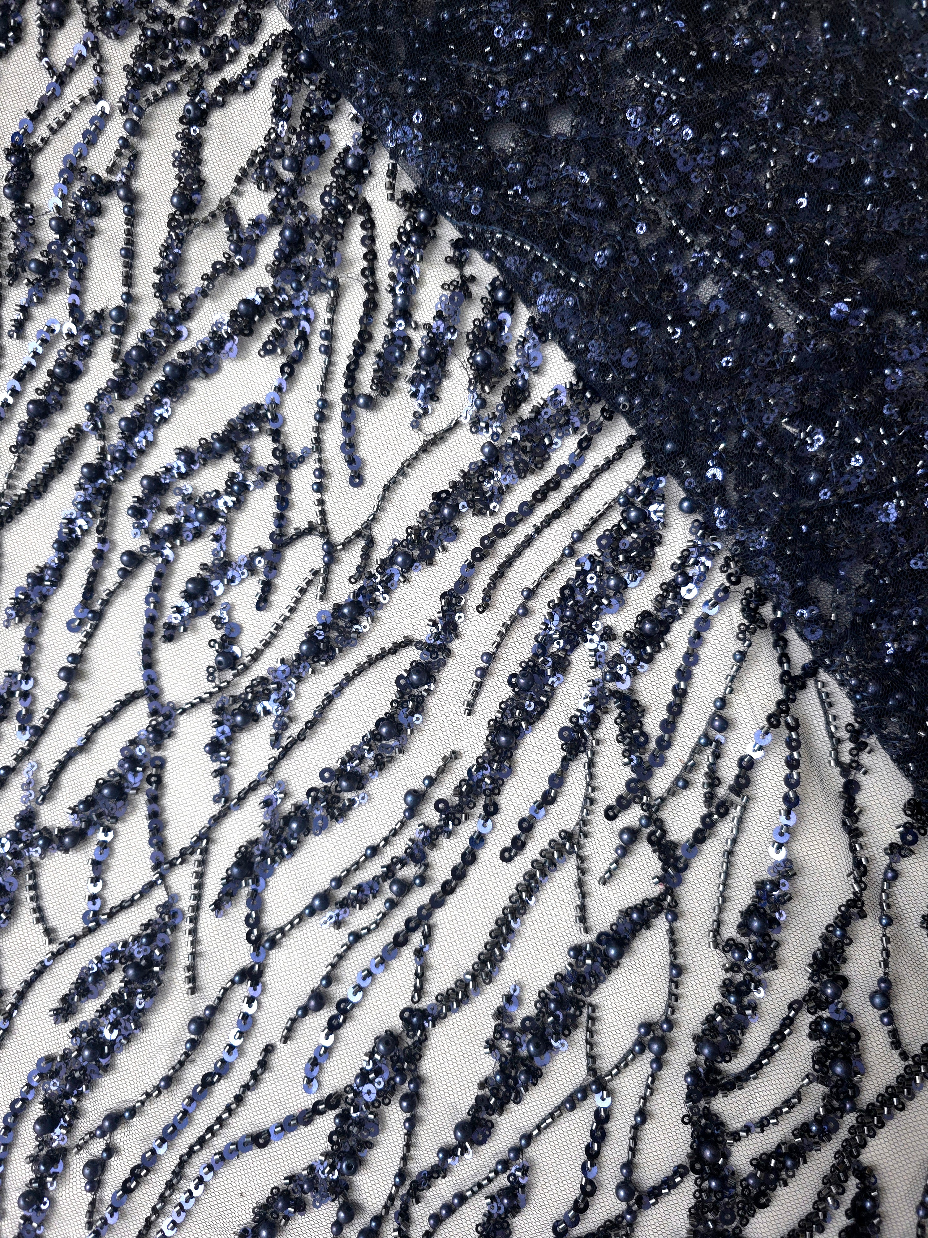 Close-up of Midnight Blue Liquid Wave beaded lace showing fluid lace texture, with flowing ripples and curved sequin embellishment.