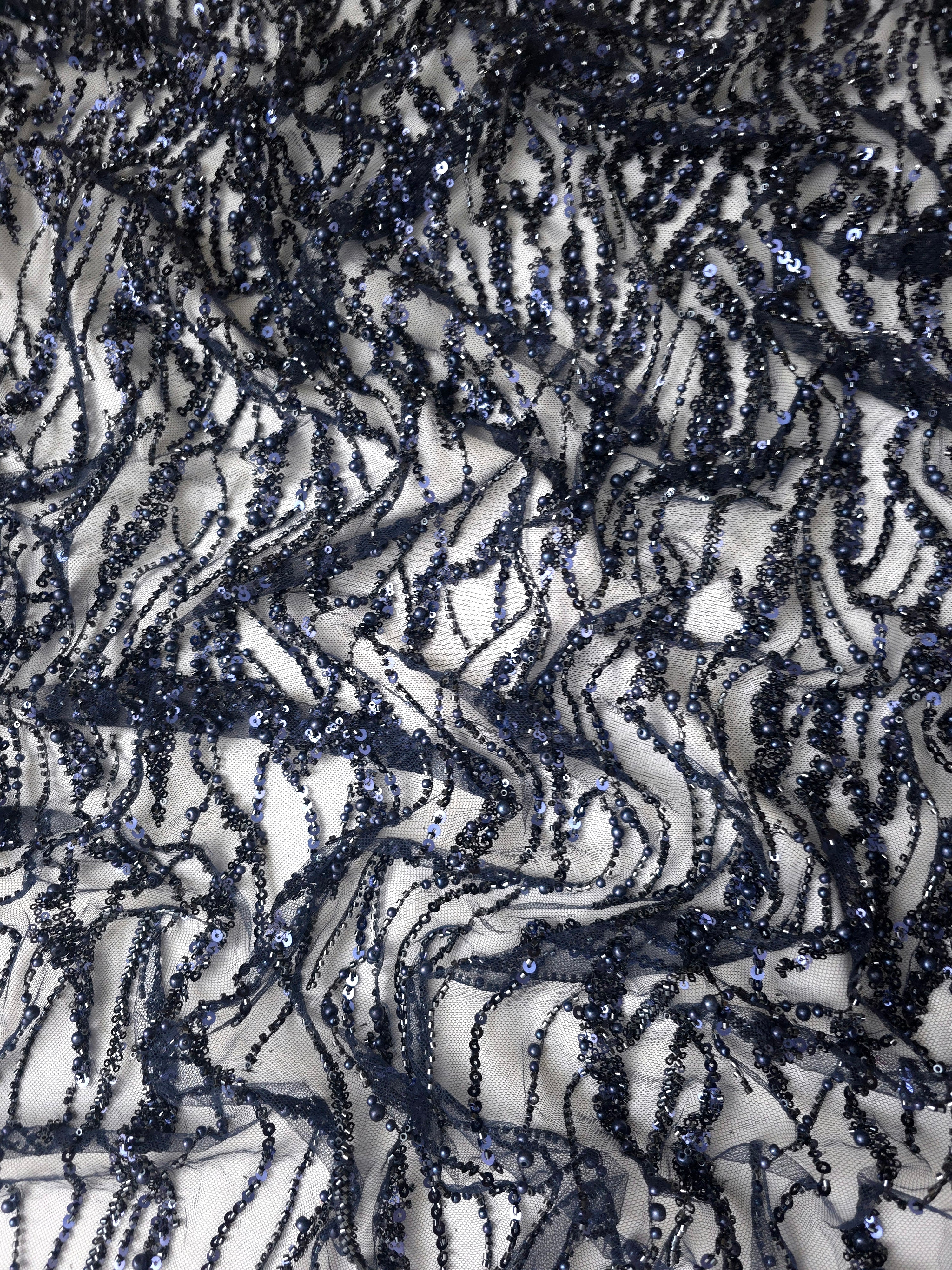 Close-up of Midnight Blue Liquid Wave beaded lace showing metallic beadwork macro, with flowing ripples and curved sequin embellishment.