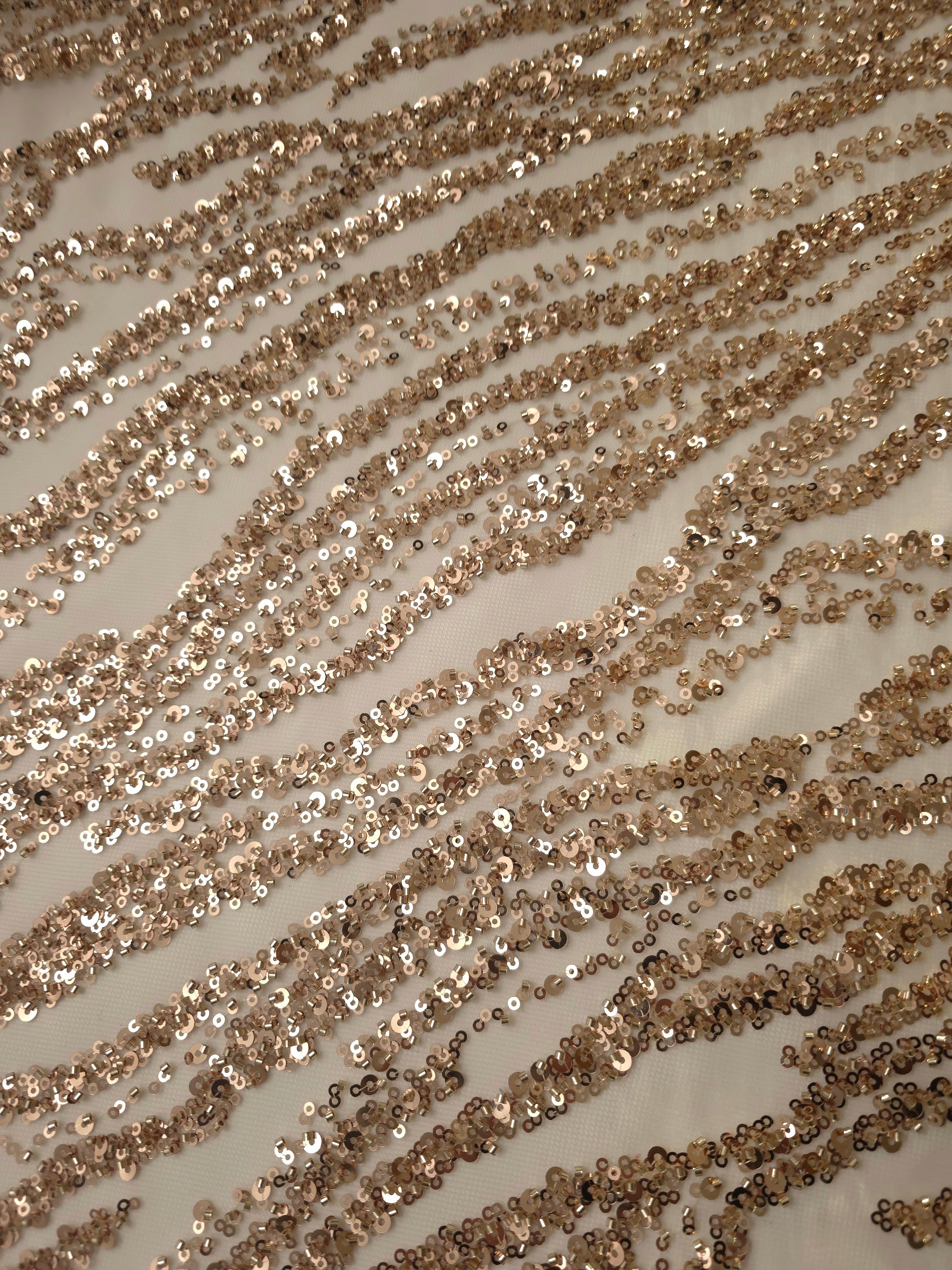 Metallic champagne-toned beadwork detailing the rippled stripes of the Zebra Strata embroidery.