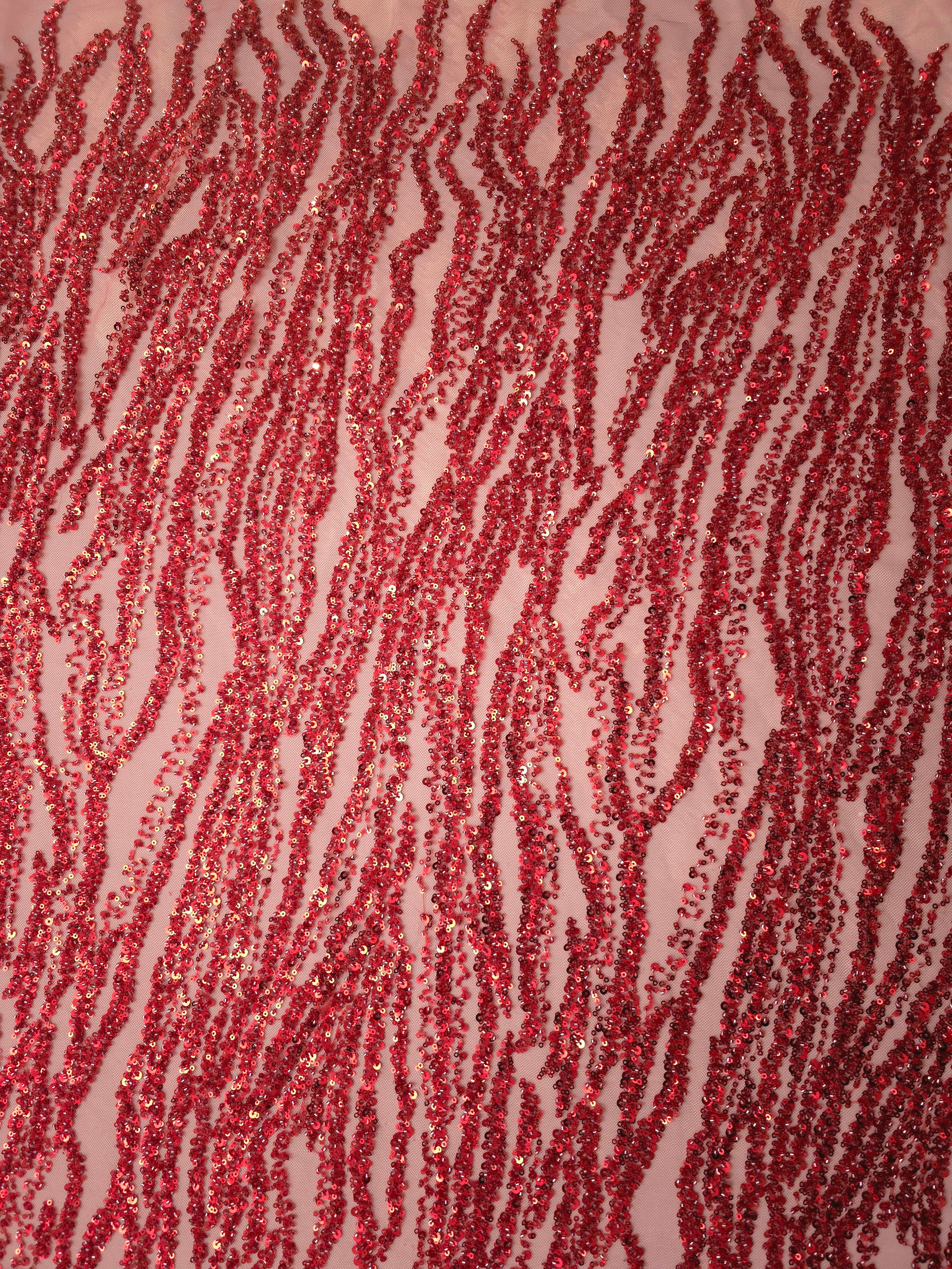 Full vertical view of ruby red embroidered lace with lengthwise flowing stripes and repeated wave details.