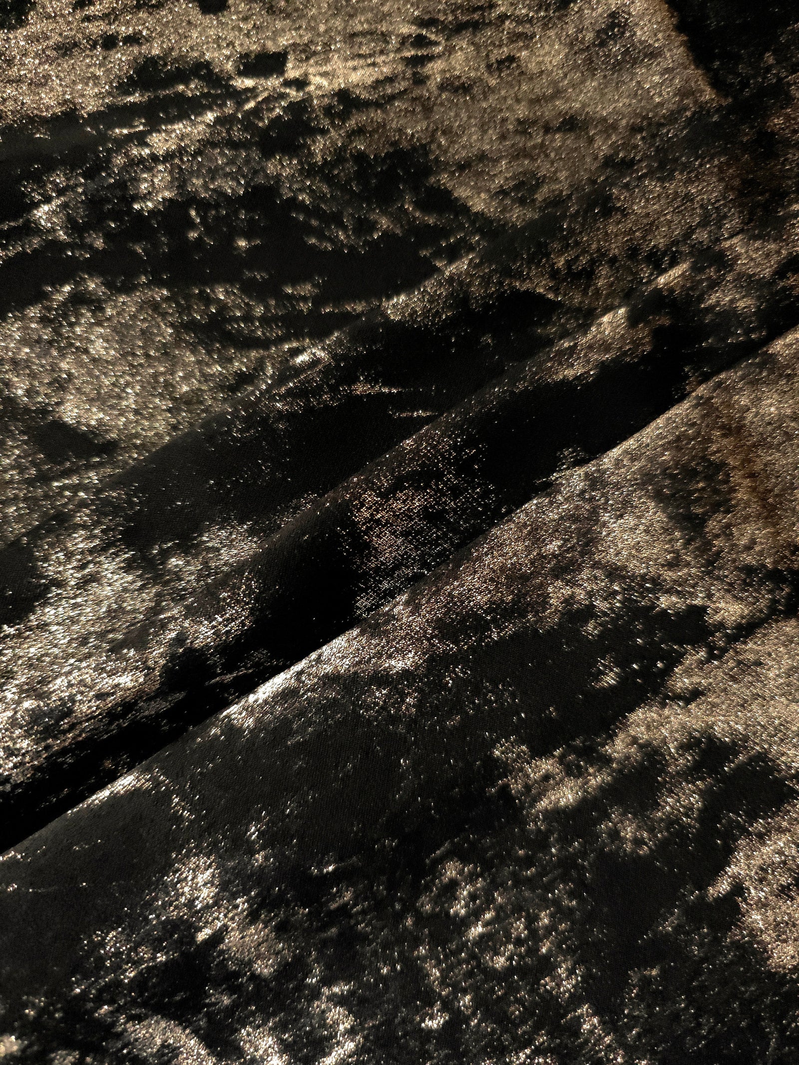 Black Bronze Lurex Italiano fabric in diagonal folds showing metallic sheen and drape for eveningwear.