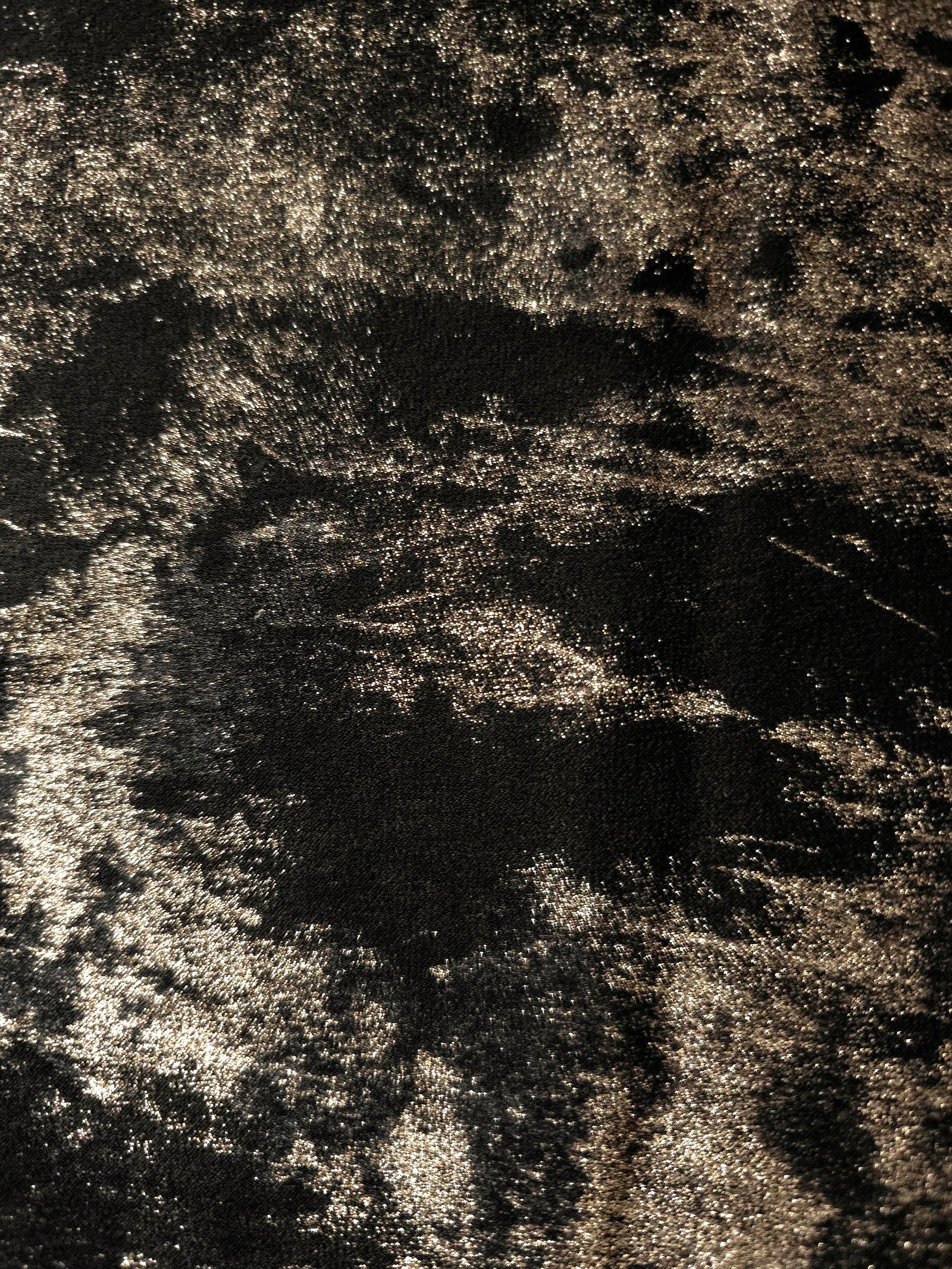 Macro close-up of Black Bronze Lurex Italiano fabric revealing metallic texture for designer apparel.