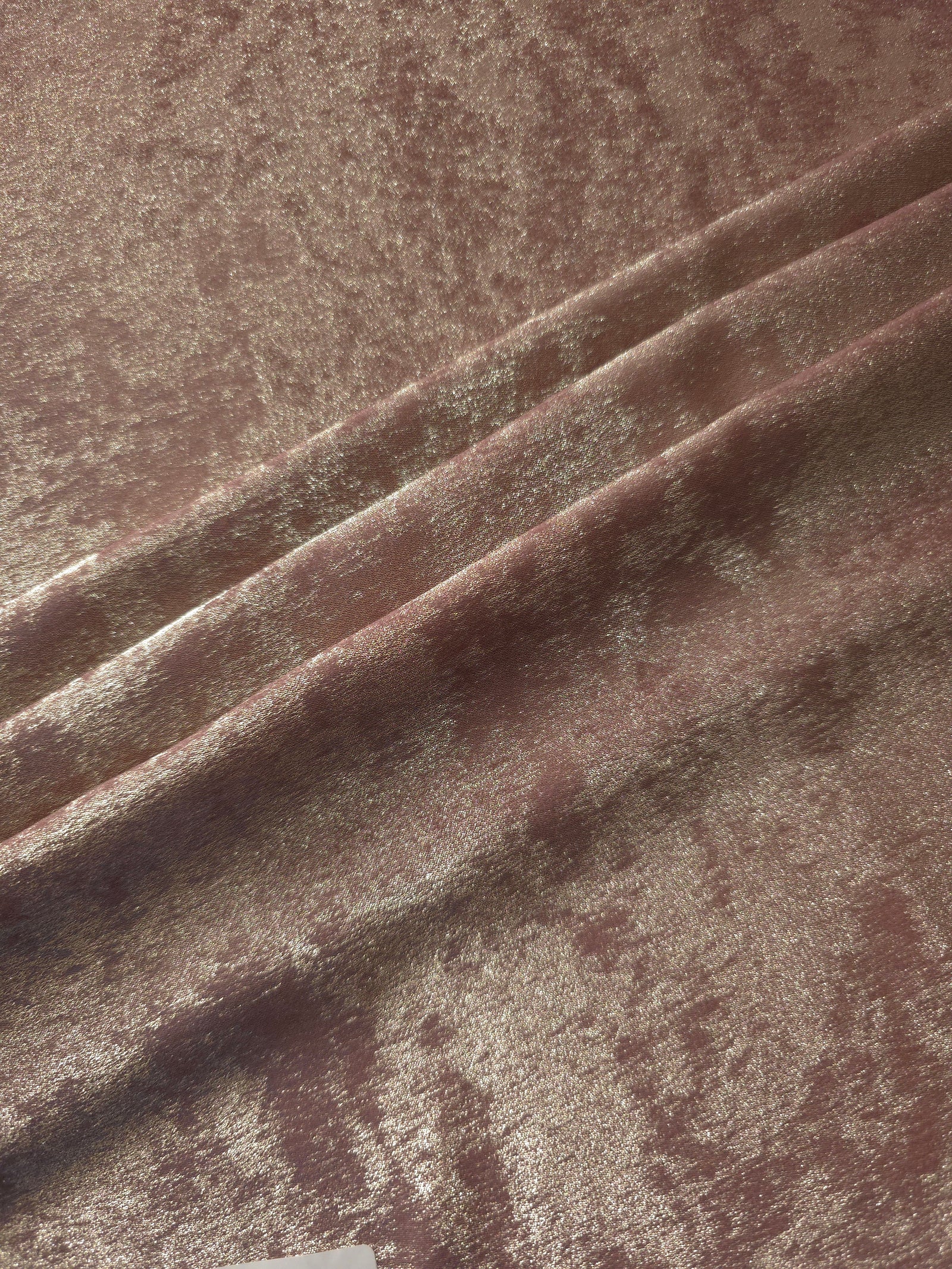 Blush Taupe Lurex Italiano fabric in diagonal folds showing metallic sheen and drape for eveningwear.