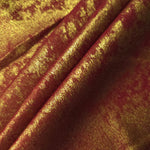 Burgundy Gold Lurex Italiano fabric in diagonal folds showing metallic sheen and drape for eveningwear.