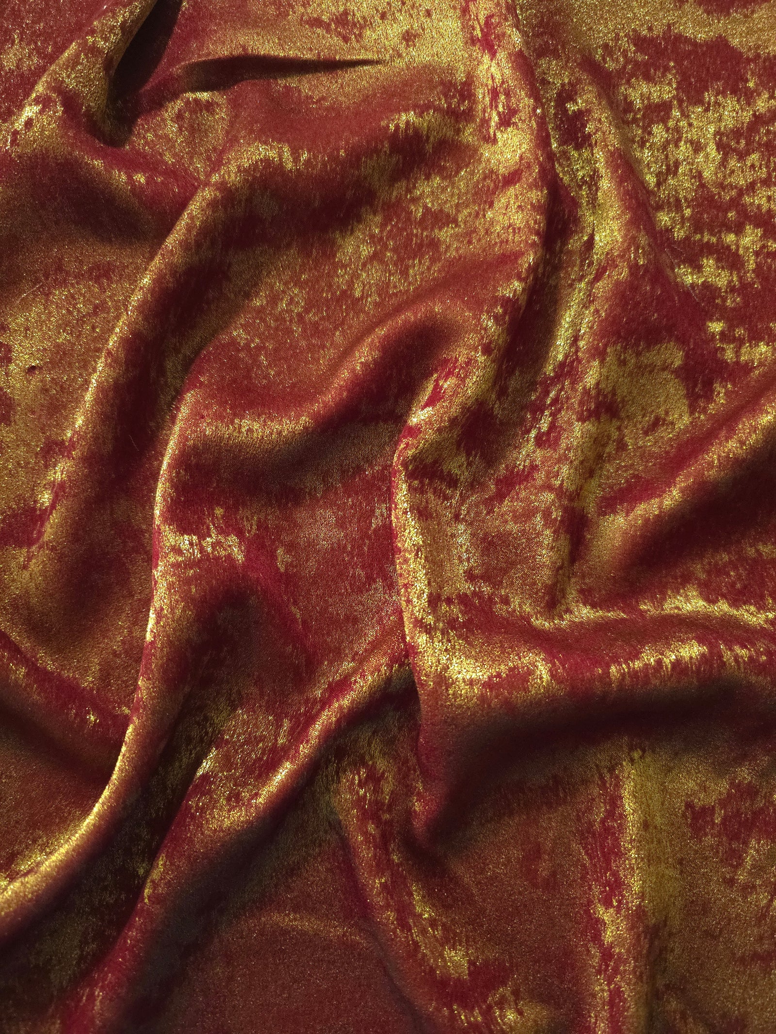 Flowing folds of Burgundy Gold Lurex Italiano fabric highlighting drape for abayas, kaftans and dresses.