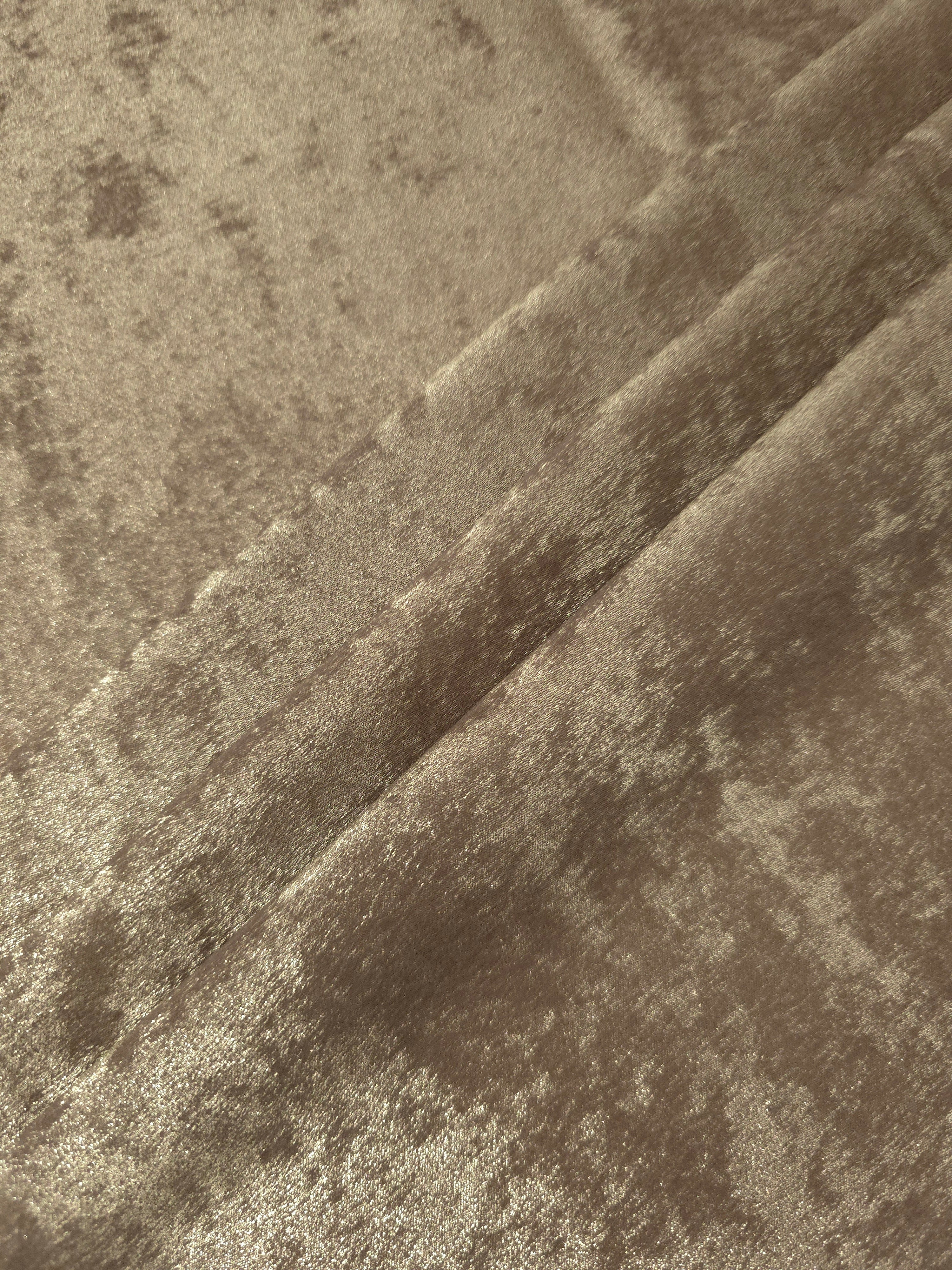 Champagne Beige Lurex Italiano fabric in diagonal folds showing metallic sheen and drape for eveningwear.