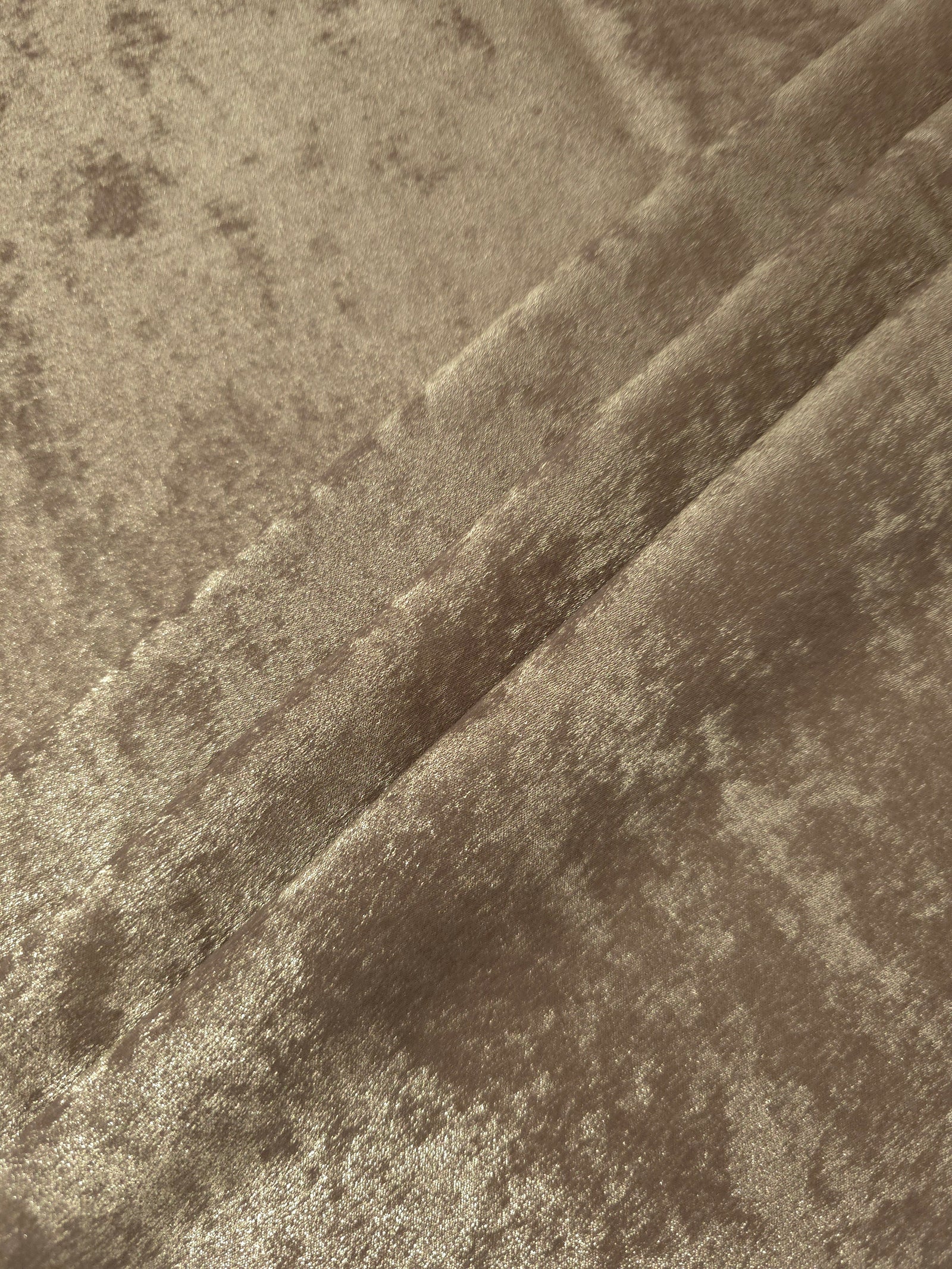 Champagne Beige Lurex Italiano fabric in diagonal folds showing metallic sheen and drape for eveningwear.