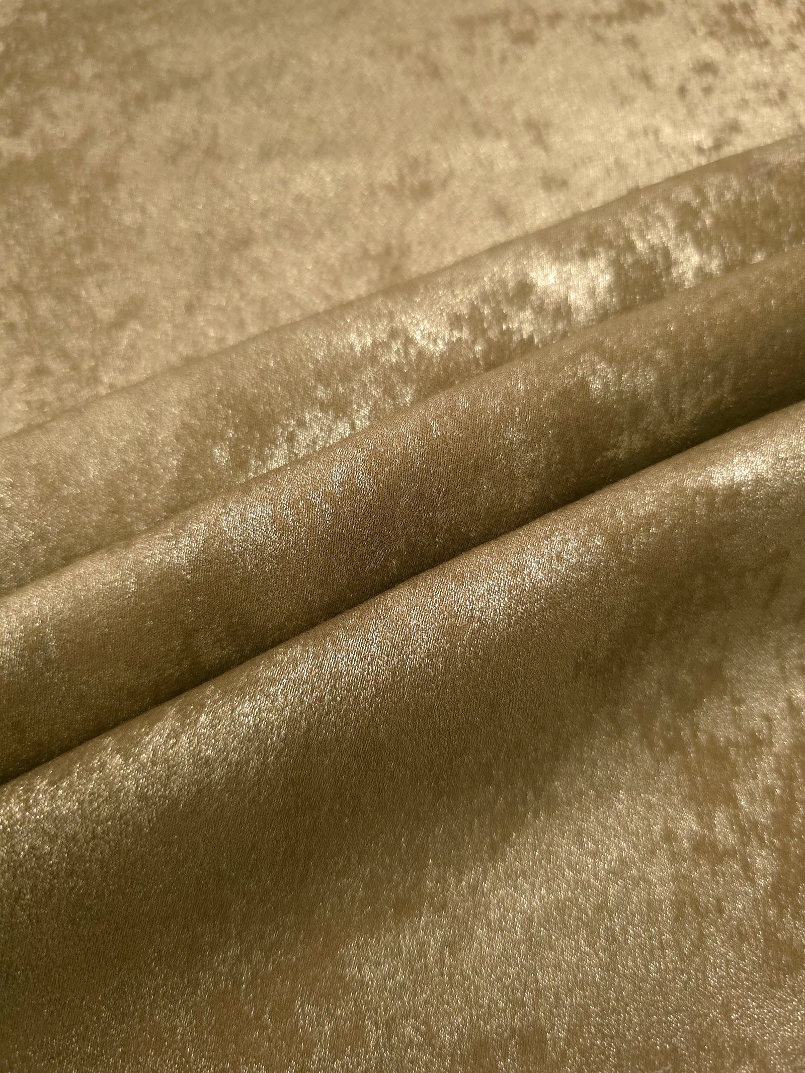 Champagne Gold Lurex Italiano fabric in diagonal folds showing metallic sheen and drape for eveningwear.