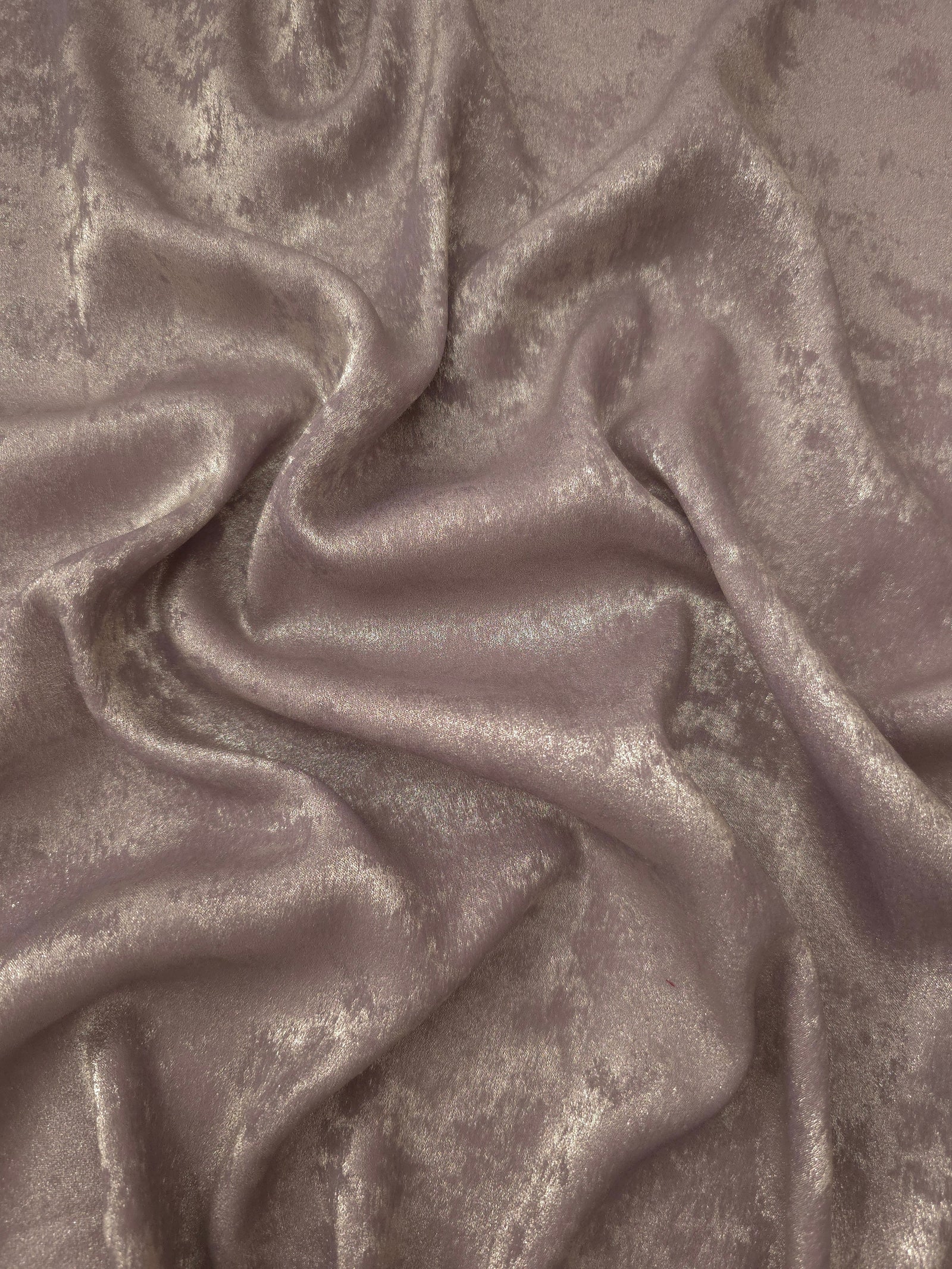 Dusty Mauve Lurex Italiano fabric in diagonal folds showing metallic sheen and drape for eveningwear.