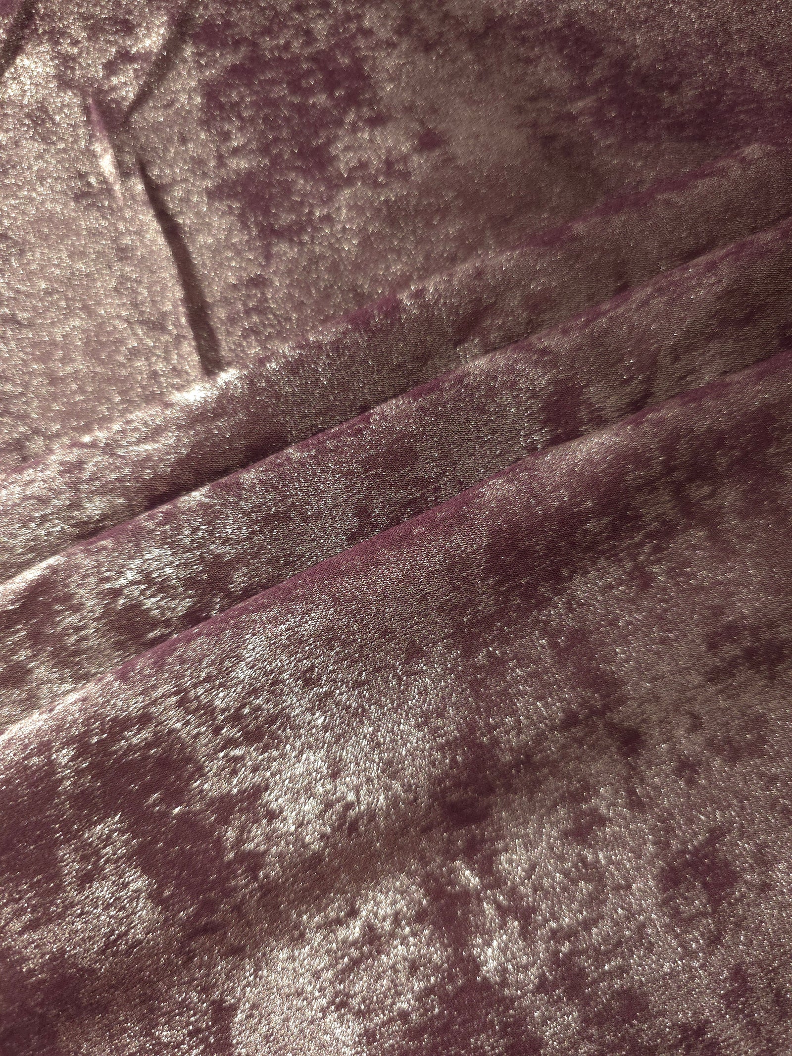 Dusty Plum Lurex Italiano fabric in diagonal folds showing metallic sheen and drape for eveningwear.