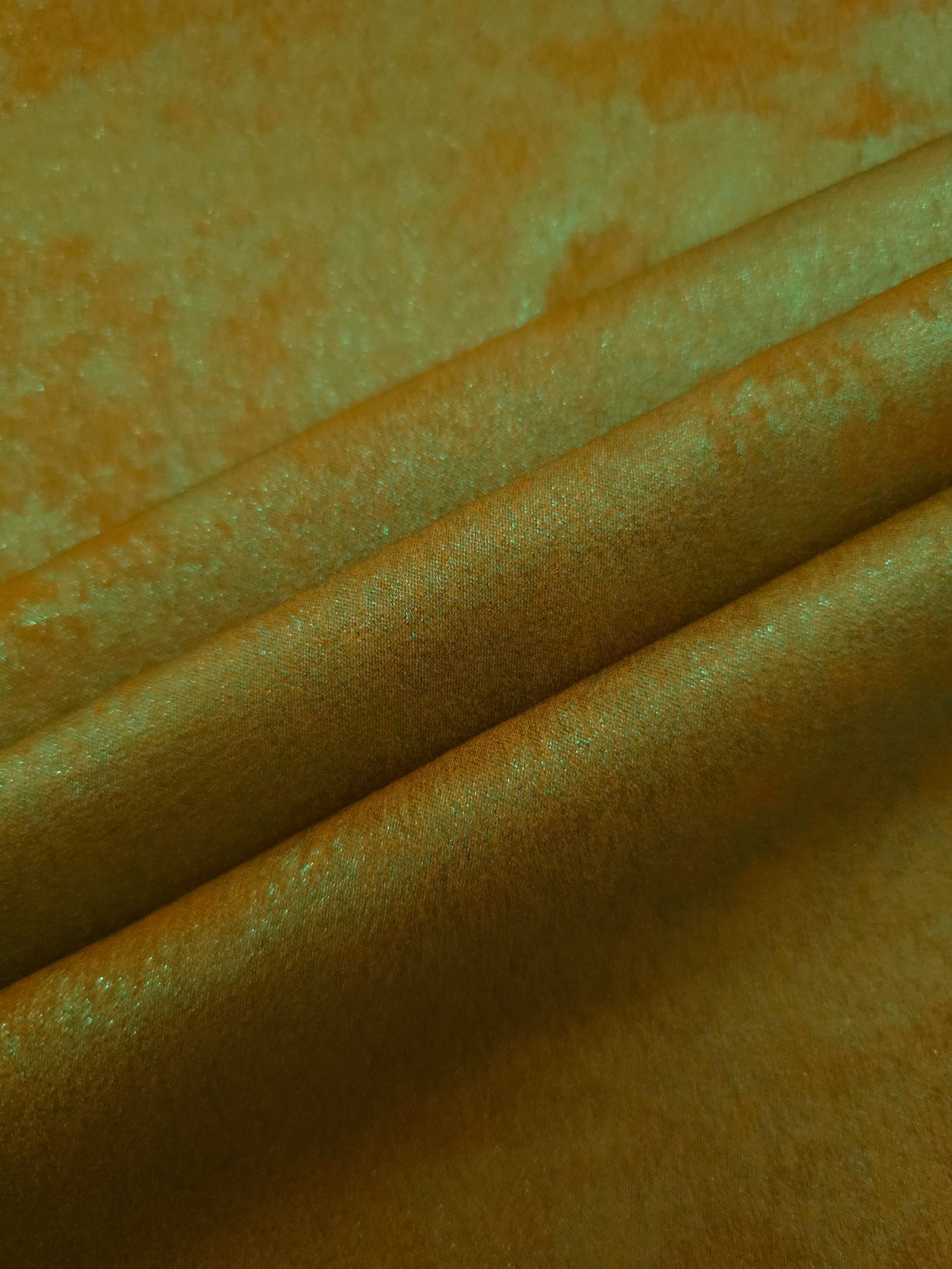 Golden Olive Lurex Italiano fabric in diagonal folds showing metallic sheen and drape for eveningwear.