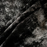Jet Black Lurex Italiano fabric in diagonal folds showing metallic sheen and drape for eveningwear.