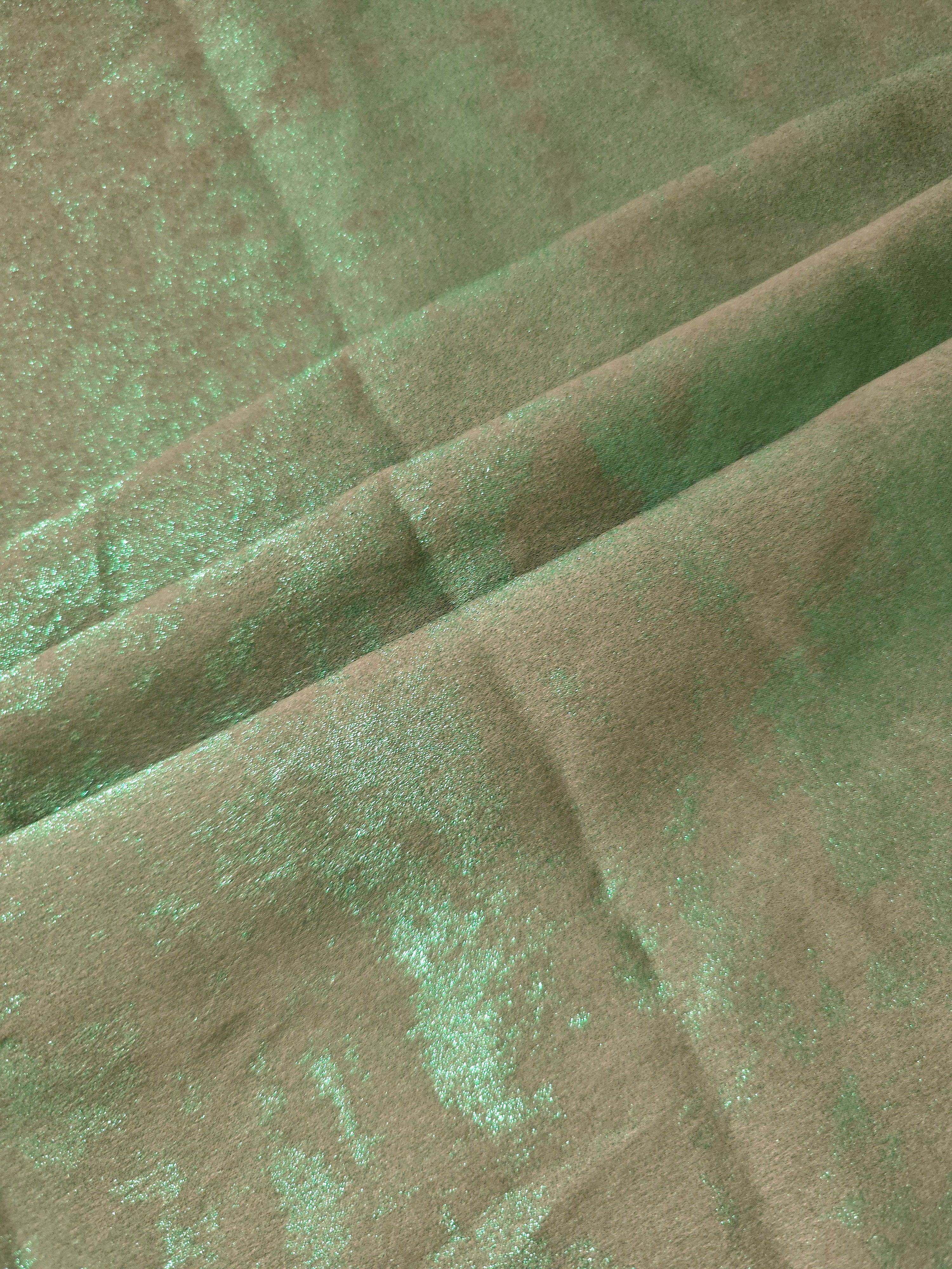 Mint Sage Lurex Italiano fabric in diagonal folds showing metallic sheen and drape for eveningwear.