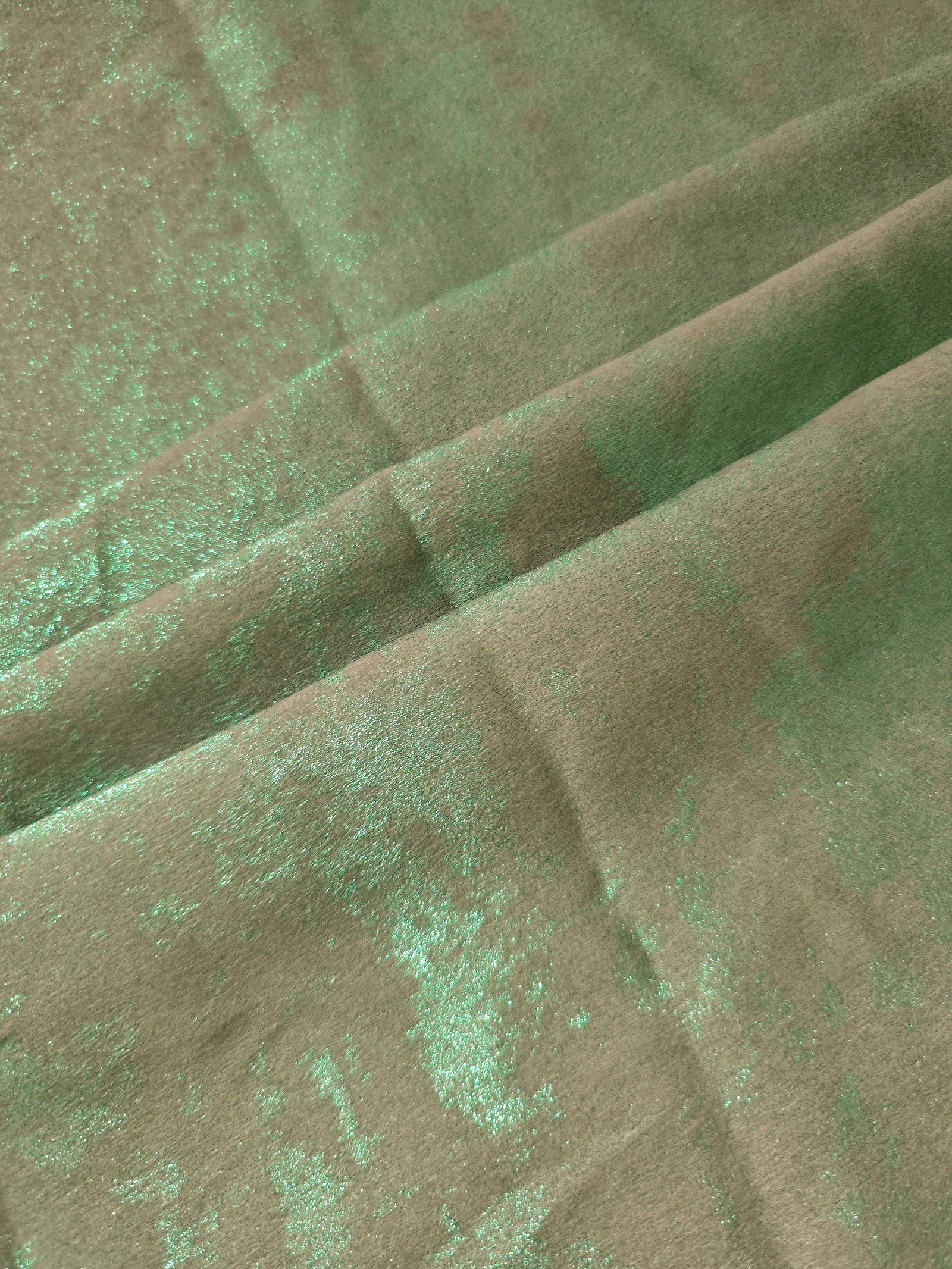 Mint Sage Lurex Italiano fabric in diagonal folds showing metallic sheen and drape for eveningwear.