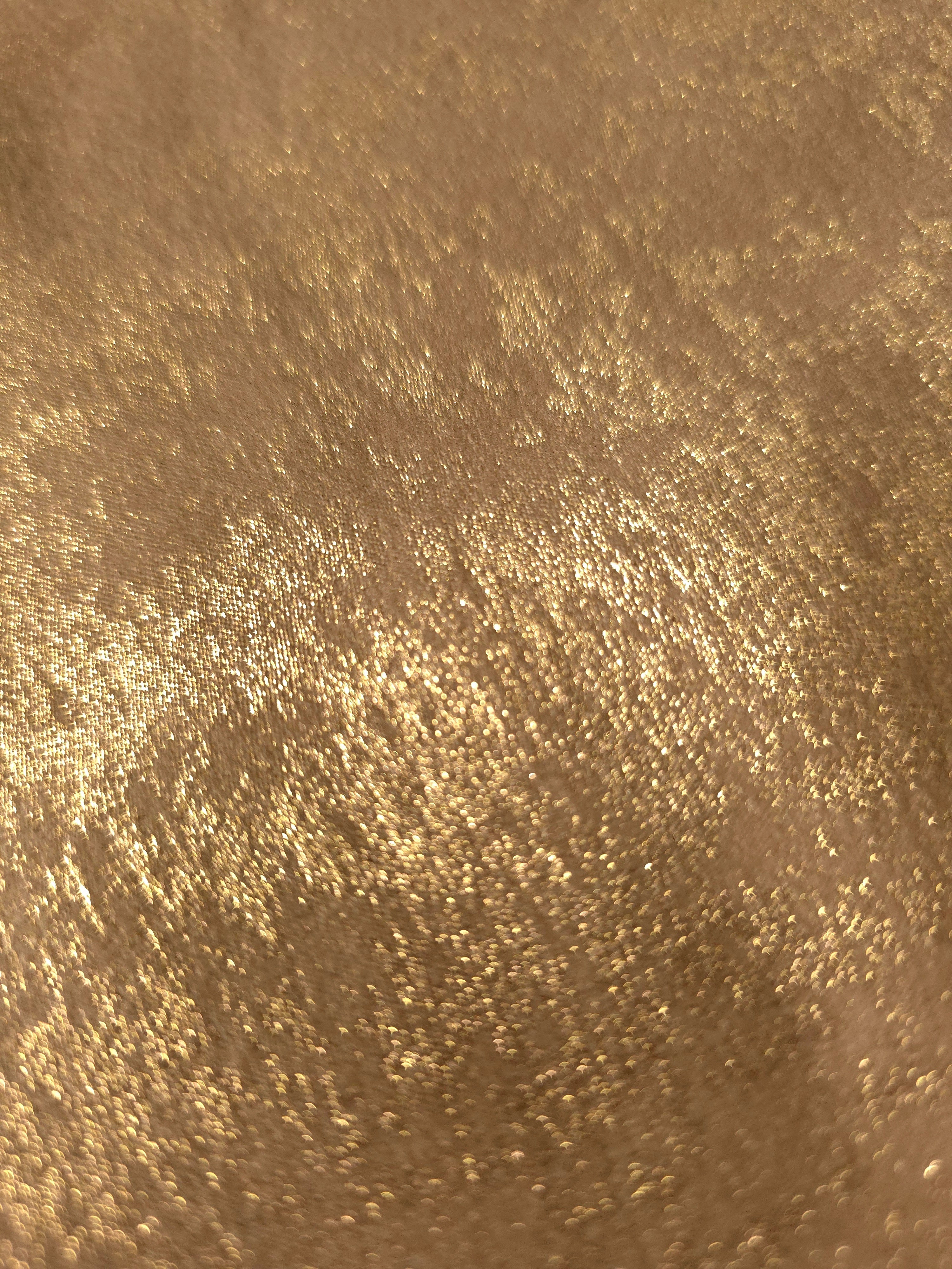 Nude Gold Lurex Italiano fabric in diagonal folds showing metallic sheen and drape for eveningwear.
