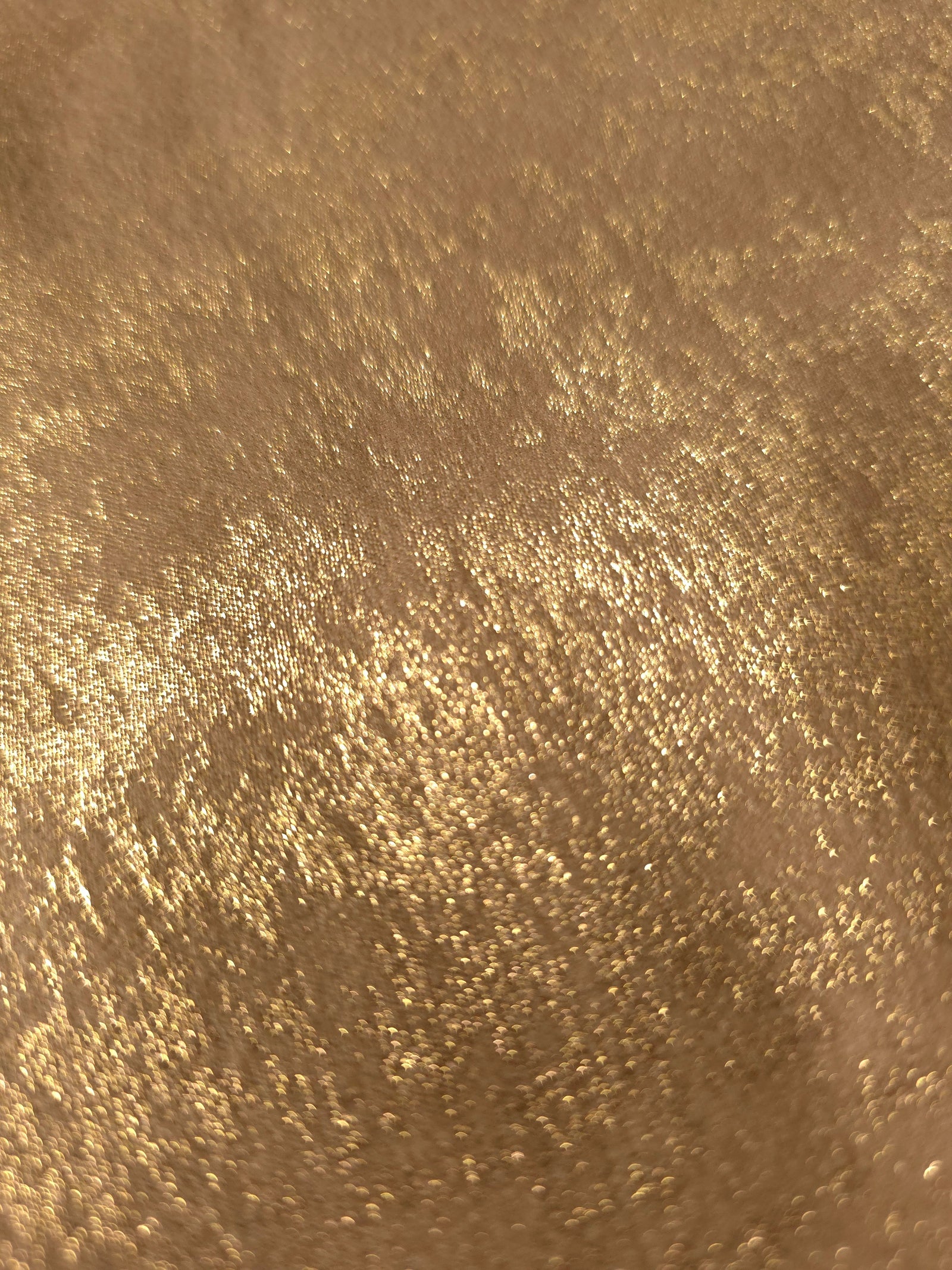 Nude Gold Lurex Italiano fabric in diagonal folds showing metallic sheen and drape for eveningwear.