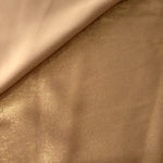 Flat view of Nude Gold Lurex Italiano fabric showing its metallic foil surface for luxury apparel.