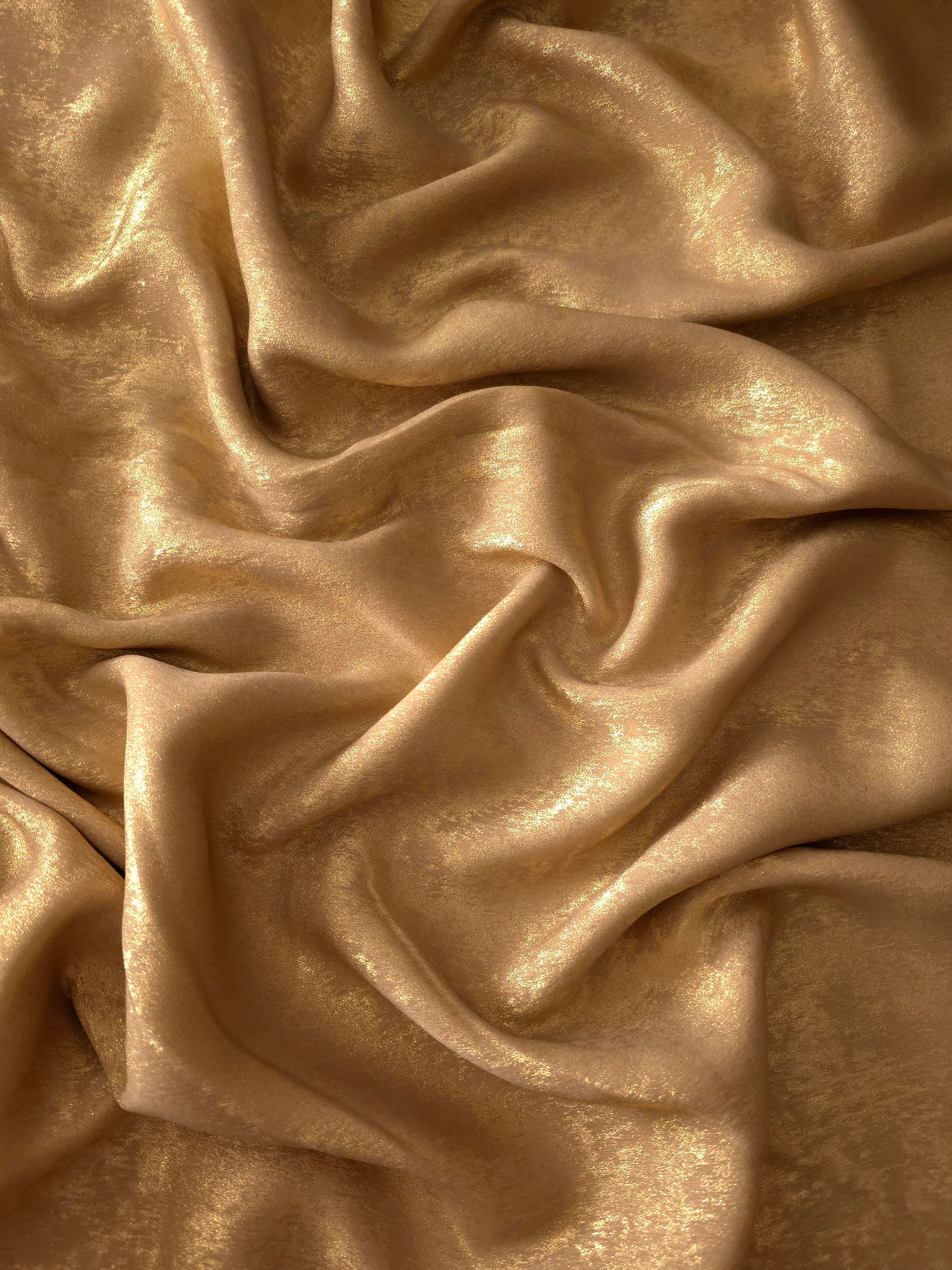 Macro close-up of Nude Gold Lurex Italiano fabric revealing metallic texture for designer apparel.
