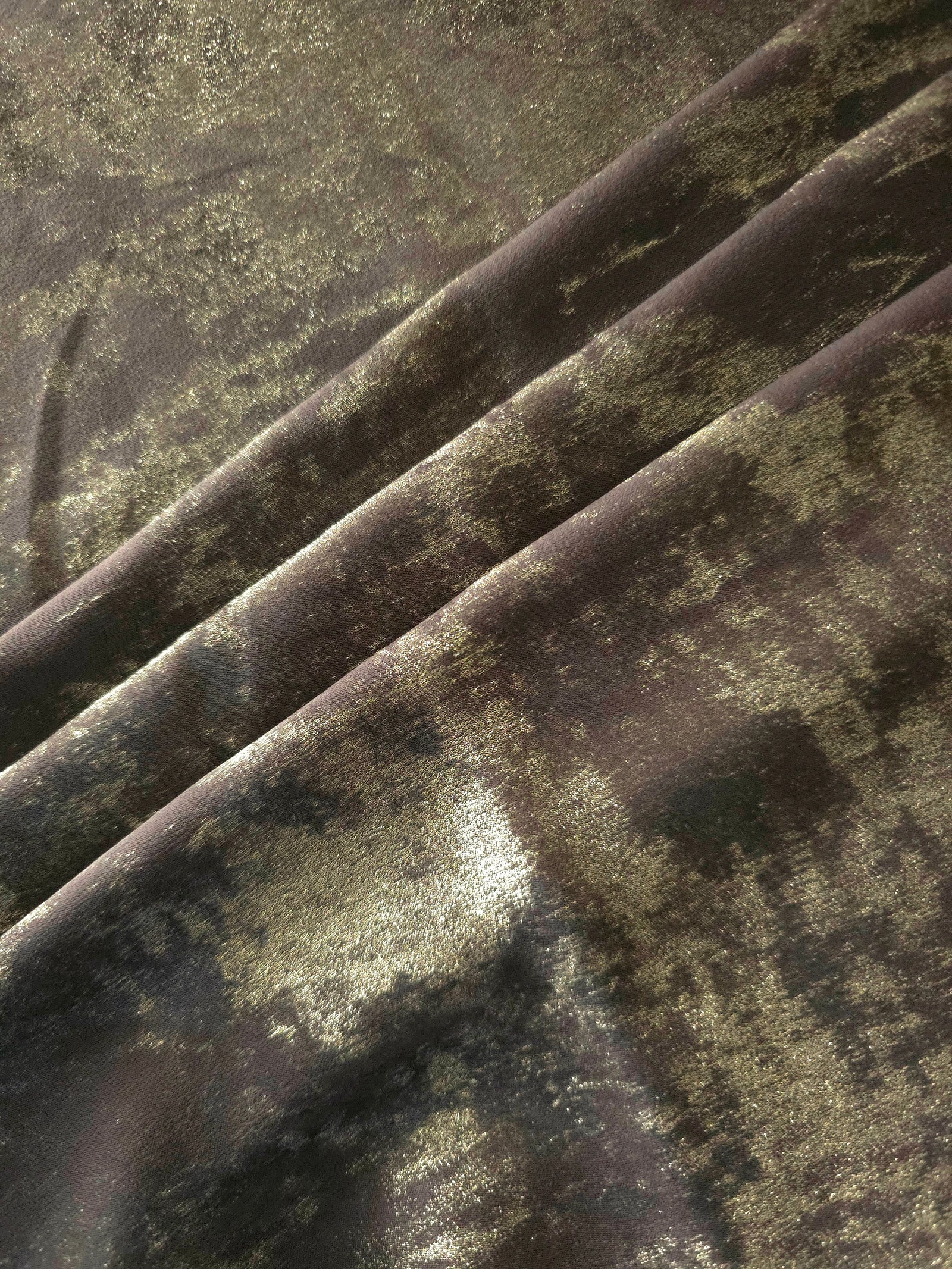Olive Bronze Lurex Italiano fabric arranged in diagonal folds to show its metallic sheen and drape for eveningwear.