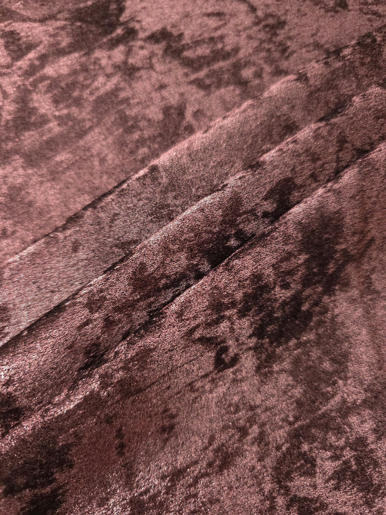 Rosewood Lurex Italiano fabric in diagonal folds showing metallic sheen and drape for eveningwear.