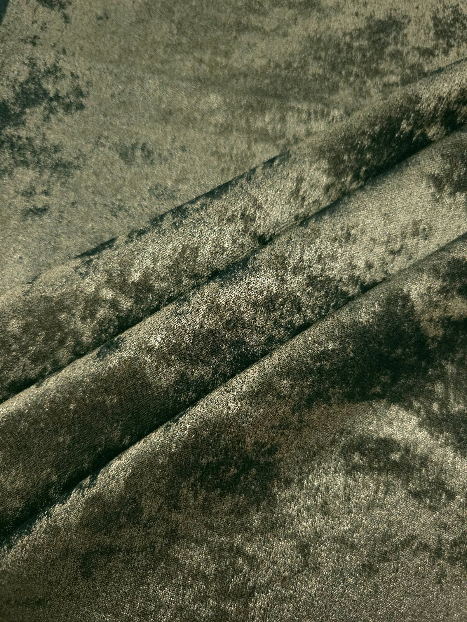 Sage Olive Lurex Italiano fabric in diagonal folds showing metallic sheen and drape for eveningwear.