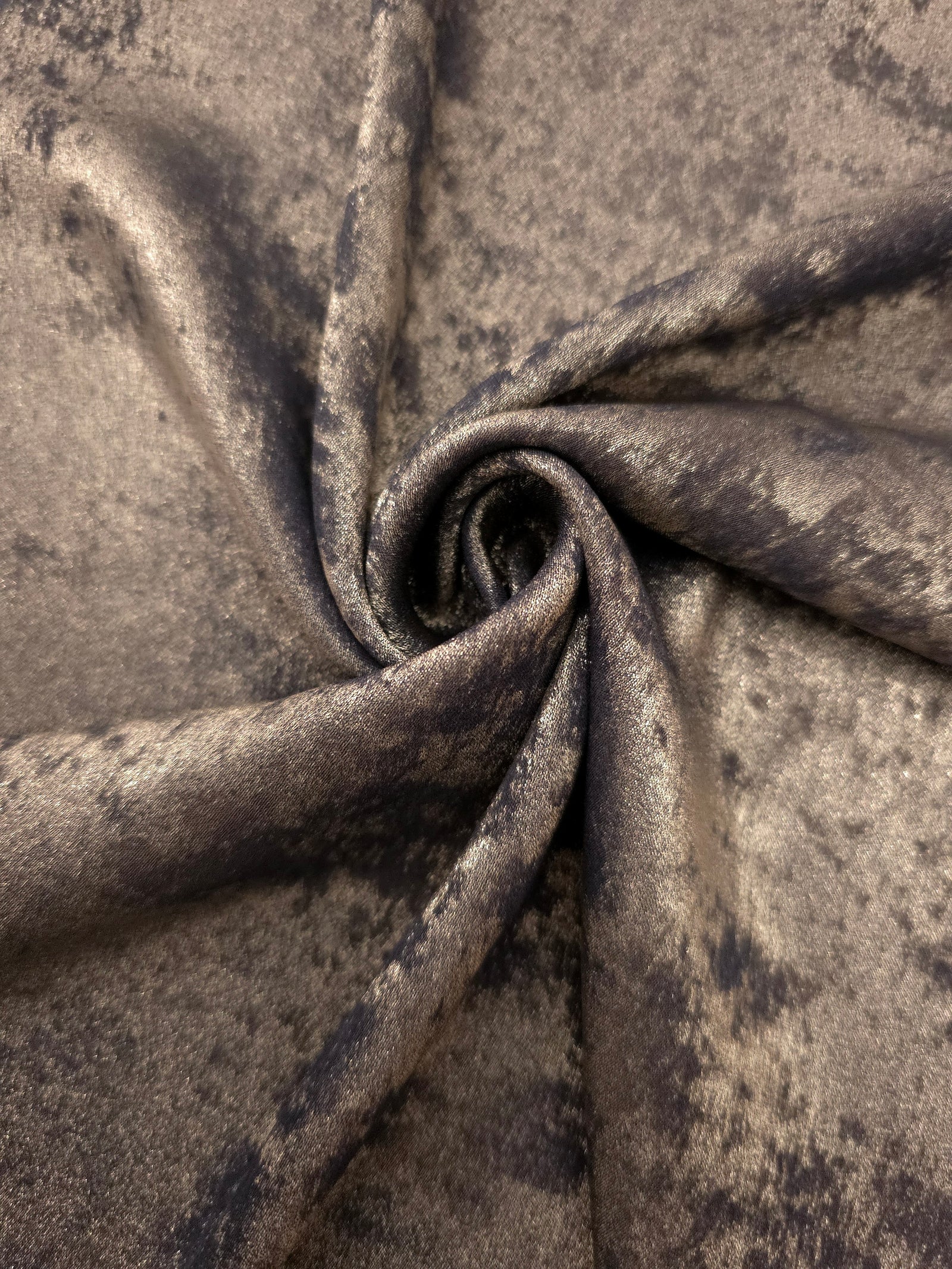 Smoky Taupe Lurex Italiano fabric in diagonal folds showing metallic sheen and drape for eveningwear.