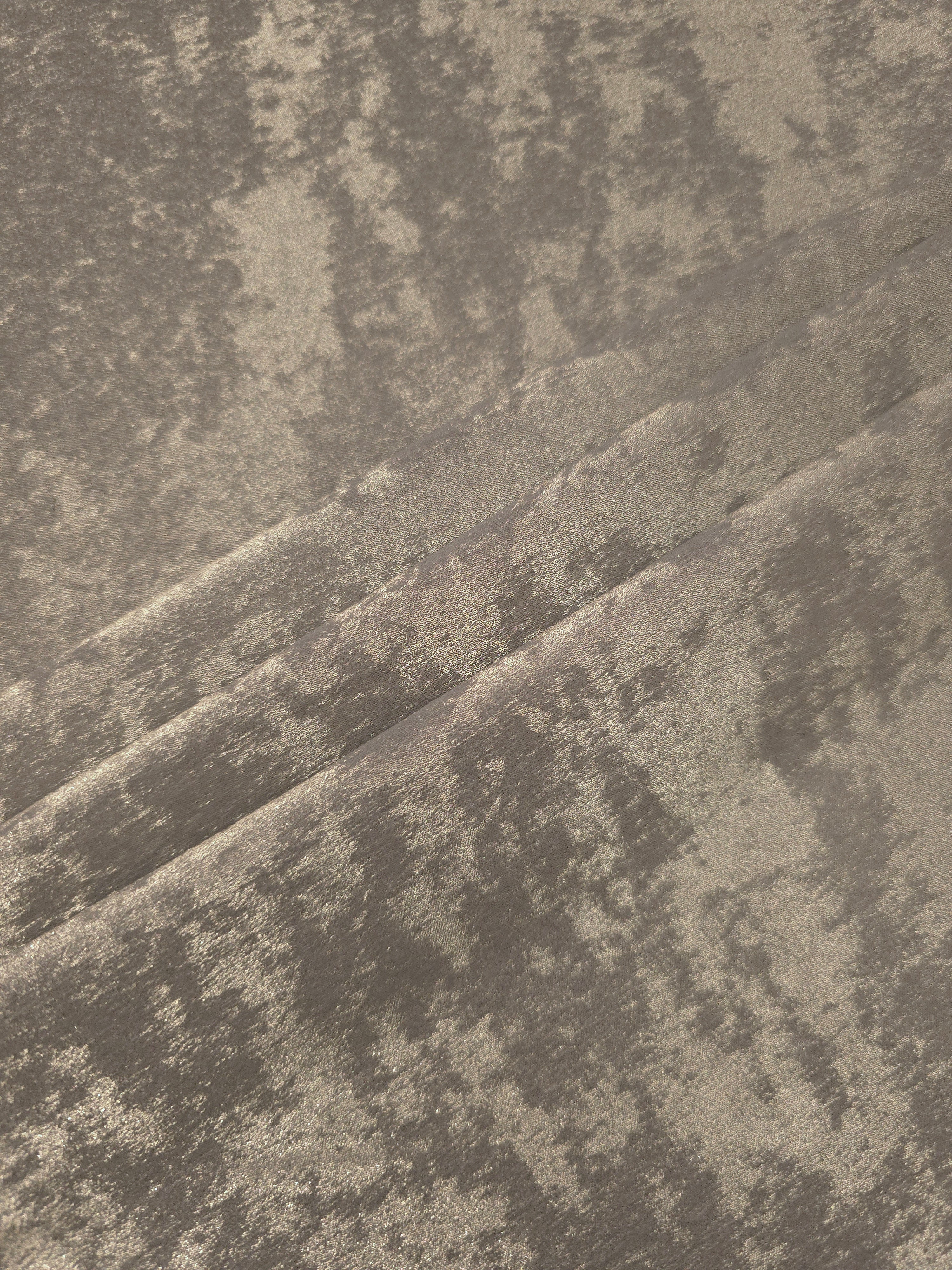 Stone Greige Lurex Italiano fabric in diagonal folds showing metallic sheen and drape for eveningwear.