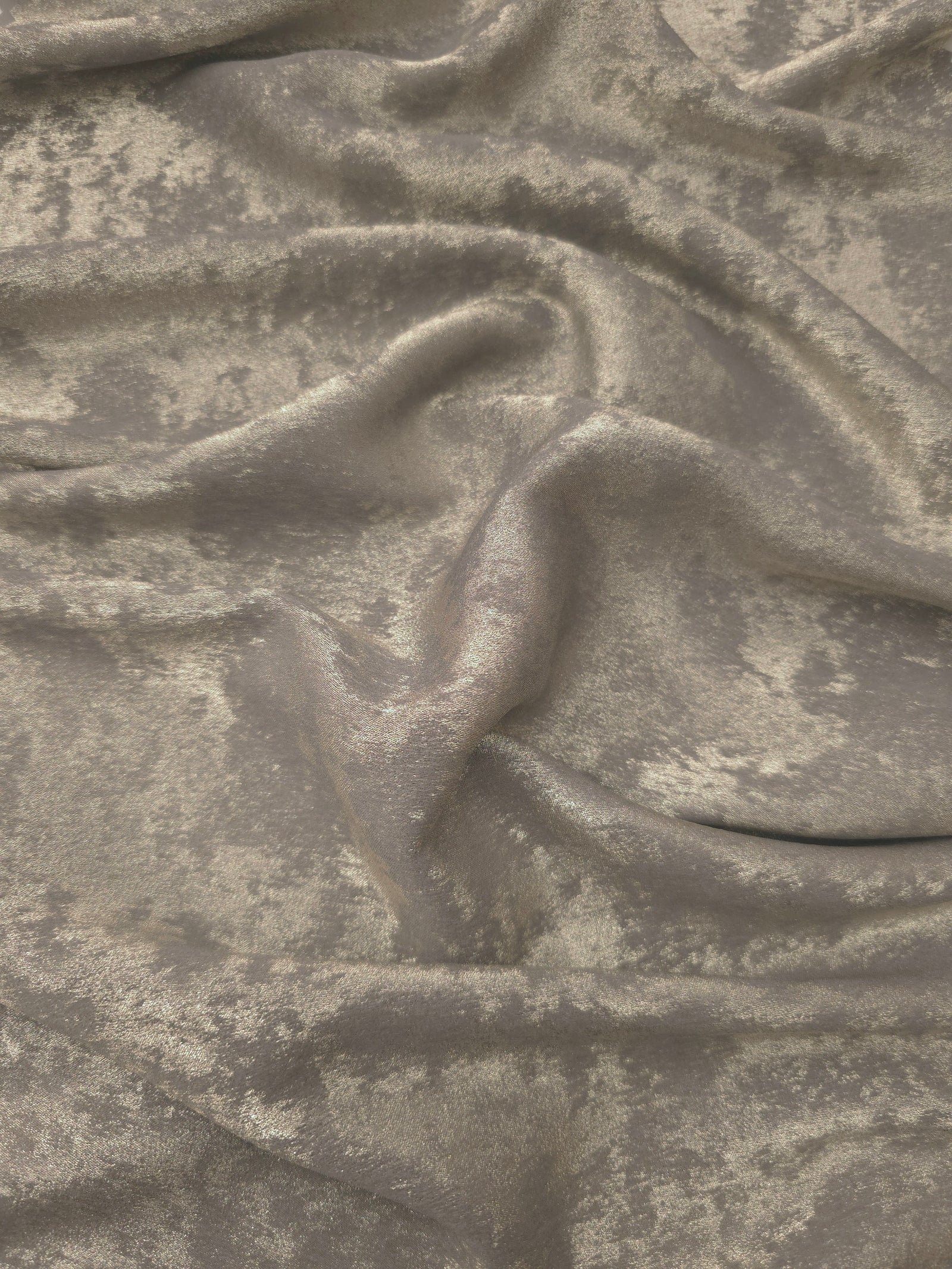 Flowing folds of Stone Greige Lurex Italiano fabric highlighting drape for abayas, kaftans and dresses.