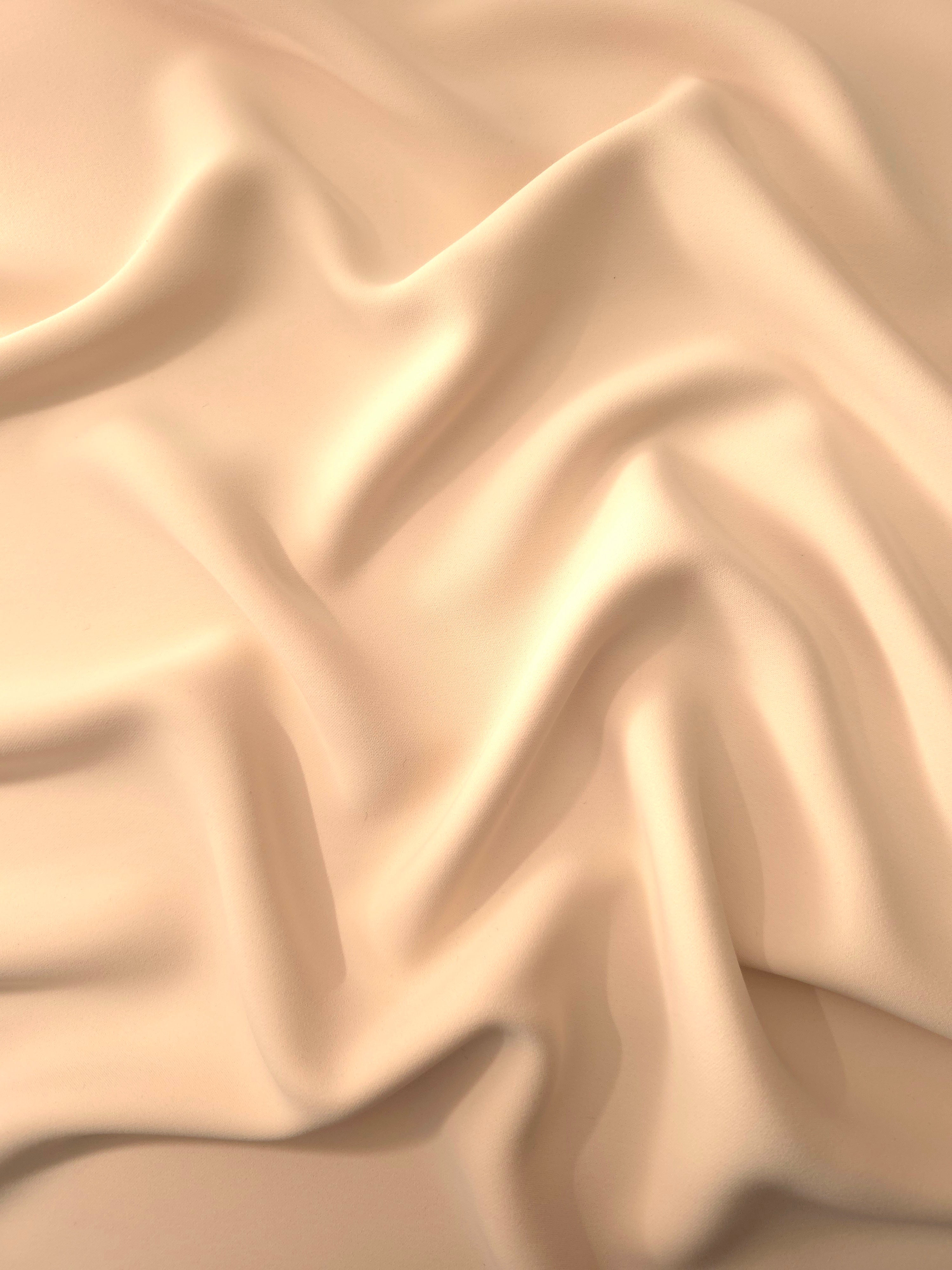 Draped Apricot Nude Silky Italian Crepe showing an elegant fall through draped folds, ideal for draped dresses, elegant tops and modest fashion.