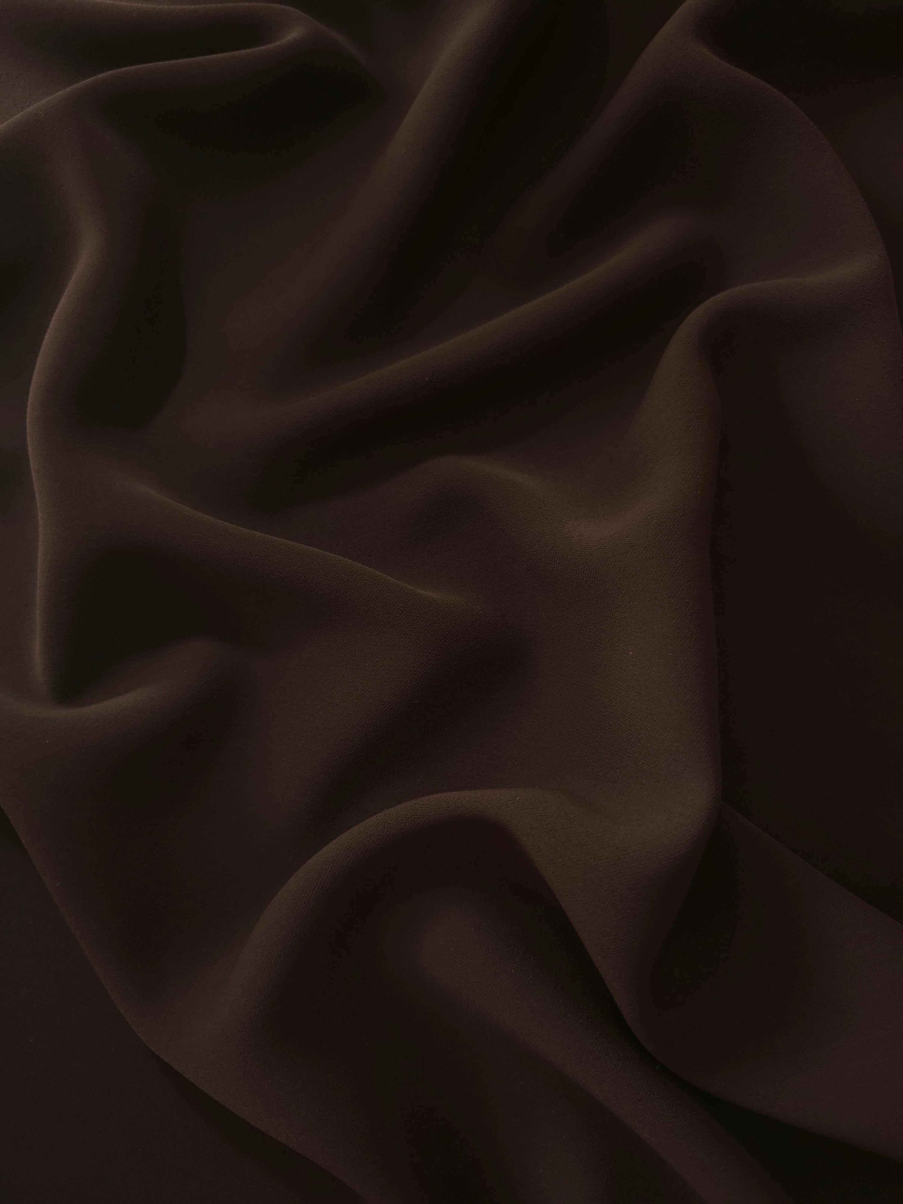 Draped Black Cocoa Silky Italian Crepe showing an elegant fall through draped folds, ideal for abayas, tunics and elegant shirt dresses.