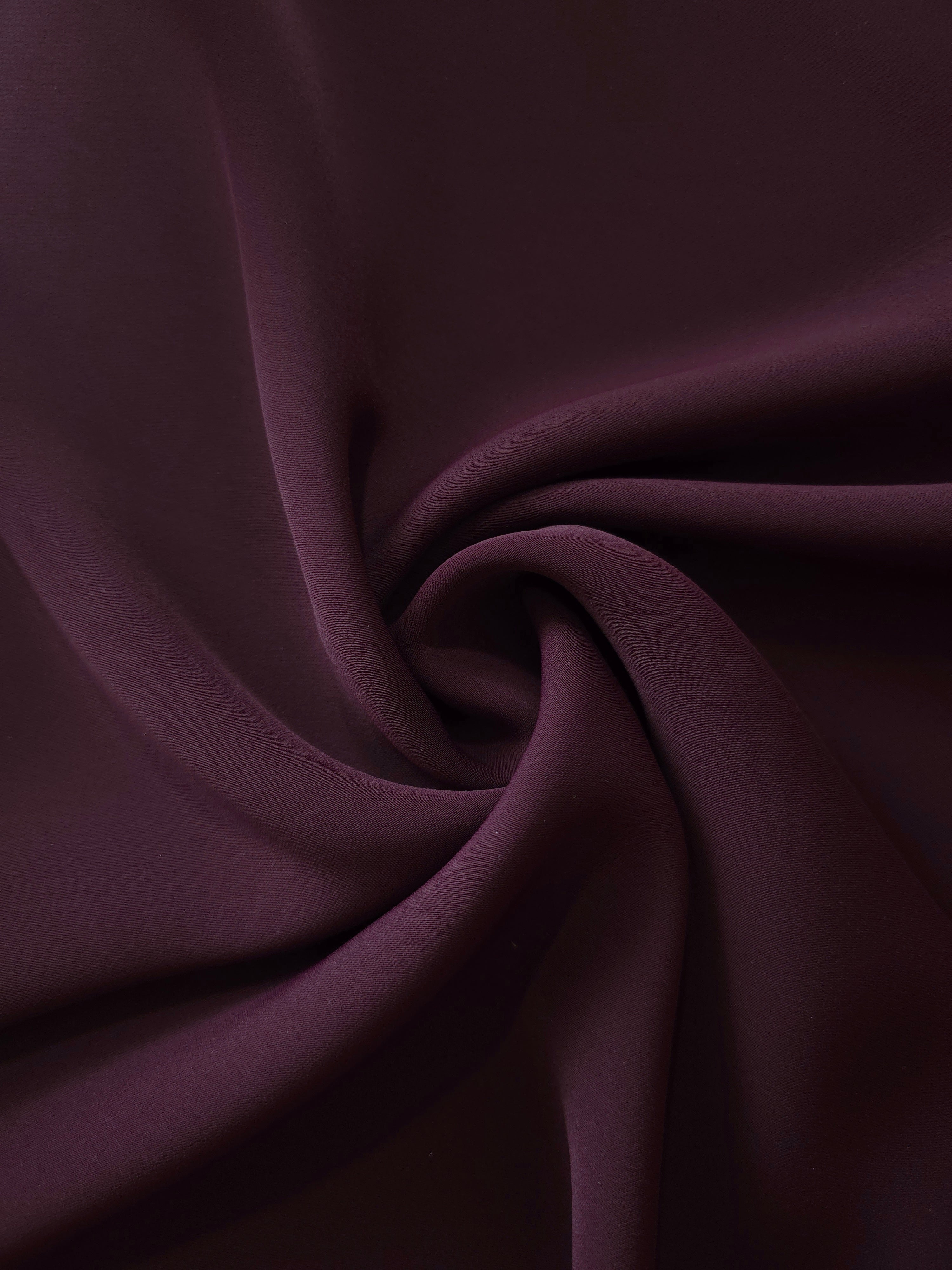 Swirled Damson Plum Silky Italian Crepe showing flowing movement in a swirl drape, versatile for bridesmaid dresses, blouses and refined separates.